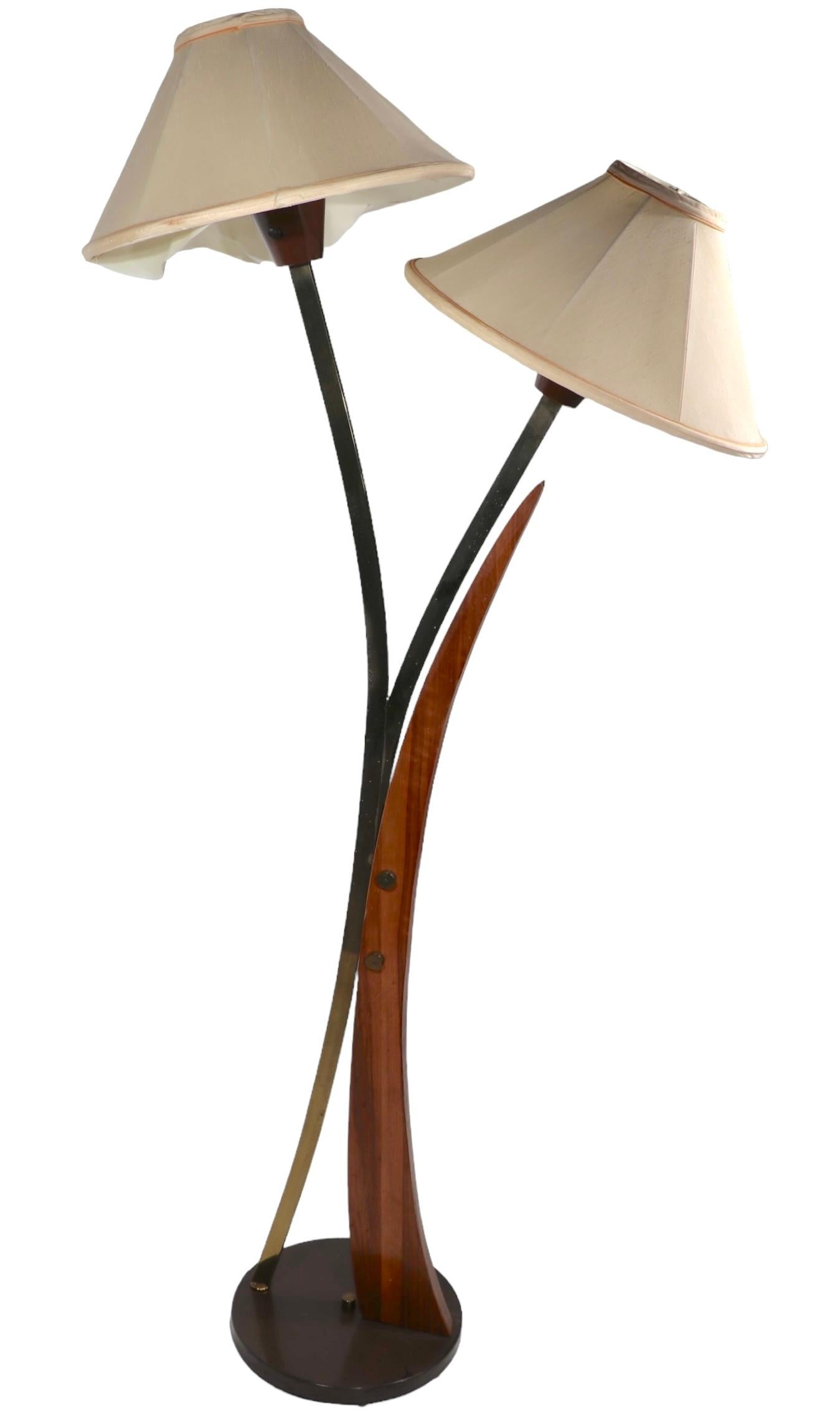 Exceptional Mid Century floor lamp having two exaggerated arms, each with a shaded light at the top. This example is in good, clean, work The sockets accept a standard size screw in bulb, each can be operated individually, shades are included but