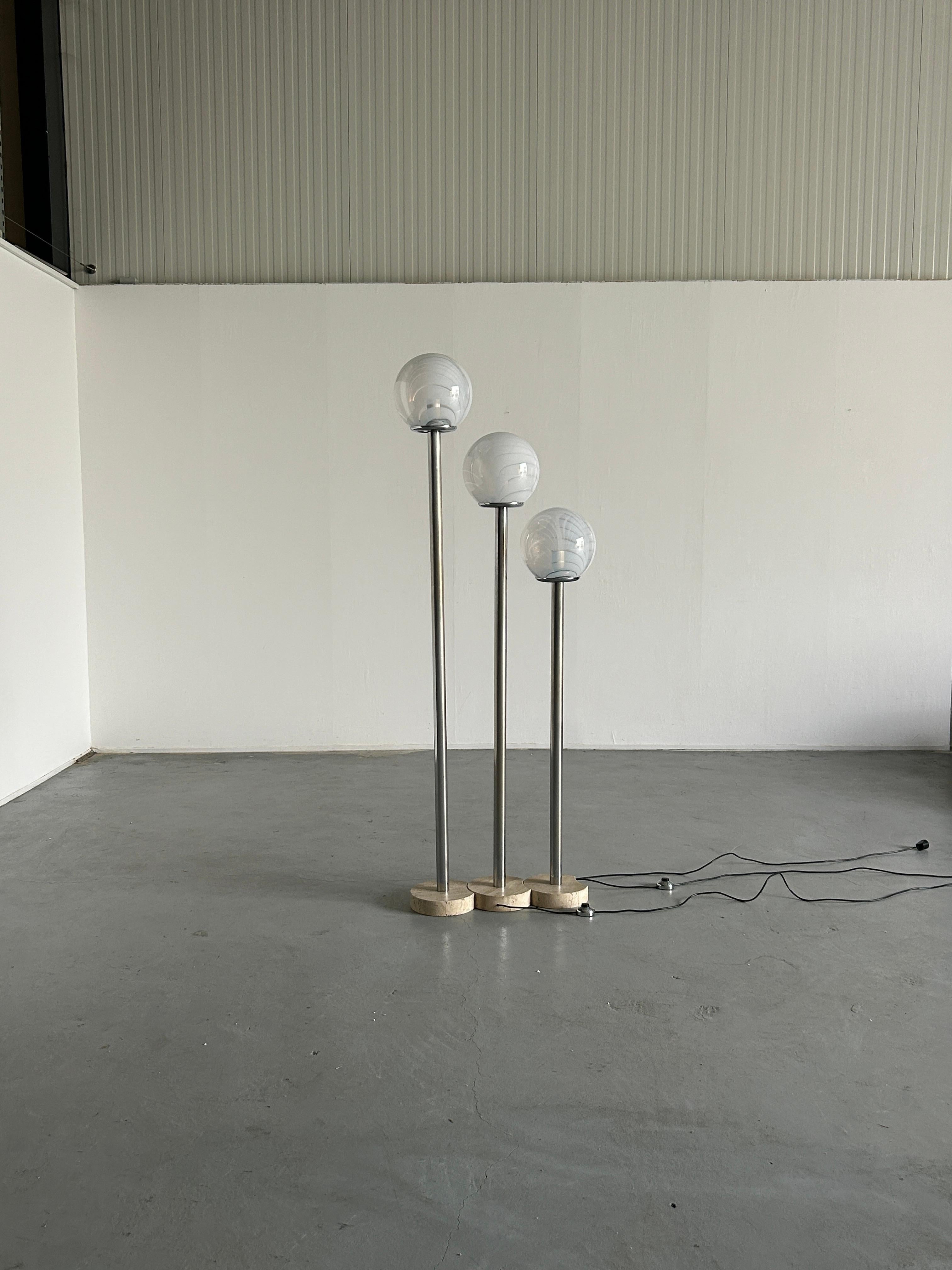 A Mid-century Modern floor lamp by Massimo & Lella Vignelli for Venini, consisting of three individual lamps, made from a travertine base, metal stem, and Murano glass globes.
Sold as a set of three.
Very good vintage condition with normal