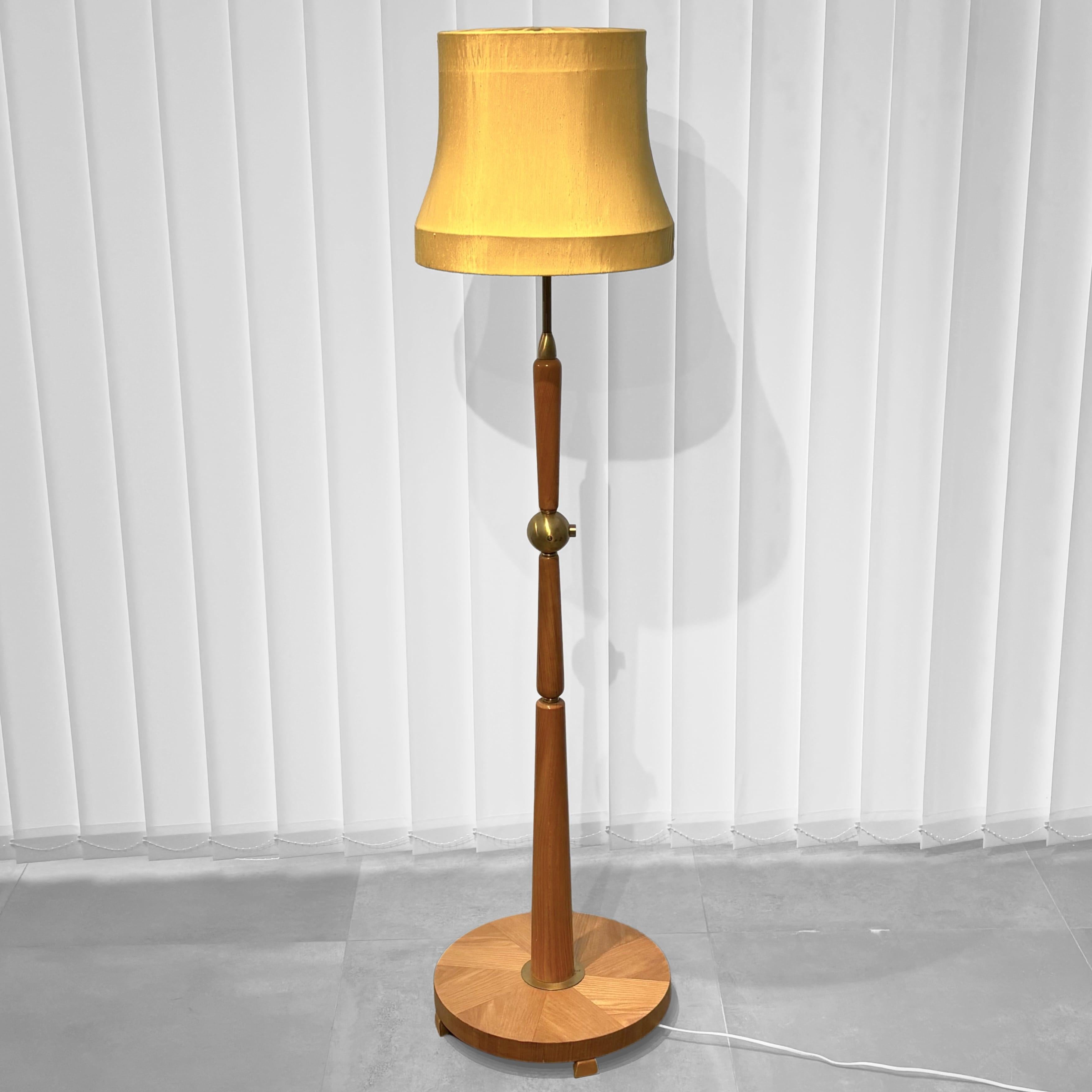 Lampadaire moderne suédois raffiné des années 1940, produit par Ivar Fransson, Industri IWO, Mariestad. Cette pièce magnifiquement fabriquée présente un pilier sculptural en placage de bouleau s'élevant d'une base circulaire à motif de soleil,
