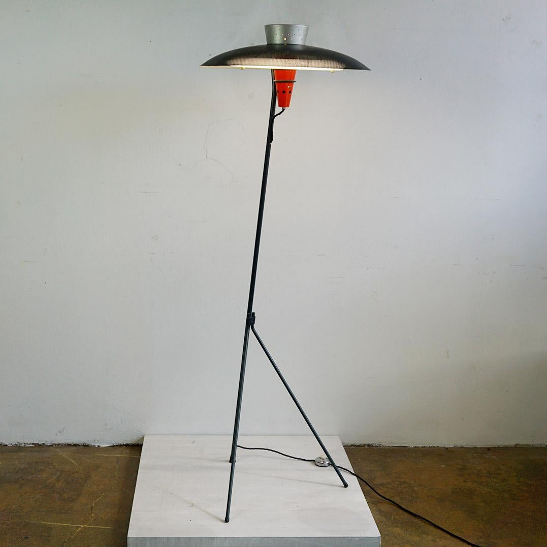 This exceptional midcentury floorlamp was designed by Louis Kalff for Philips Netherlands in the 1950s and stands out as a truly rare gem in Dutch design! It showcases a slender grey metal arm anchored to a tripod base, cradling a vibrant red metal