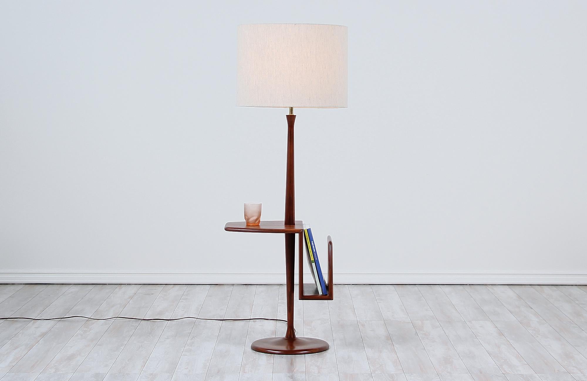 Vintage modern floor lamp designed and manufactured by Laurel Lamp Co. in the United States circa 1960s. This beautiful Mid-Century Modern lamp features a tall and solid walnut wood frame with stunning grain detail throughout adding a warm flair to