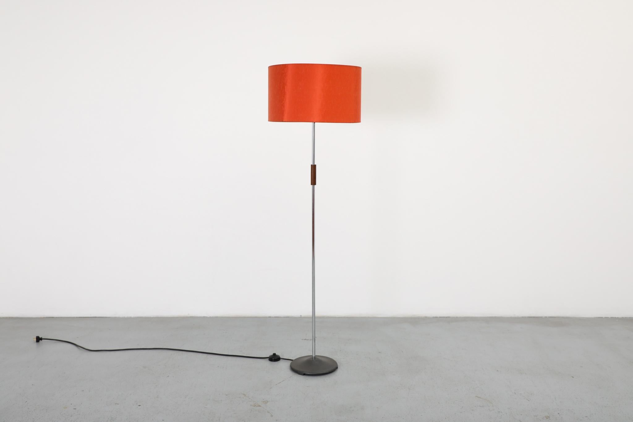 Un lampadaire classique du milieu du siècle, qui se distingue par son abat-jour original et vibrant en écorce orange texturée. Cette pièce élégante présente une tige en chrome poli, rehaussée d'un chaleureux morceau de bois de rose, et repose sur