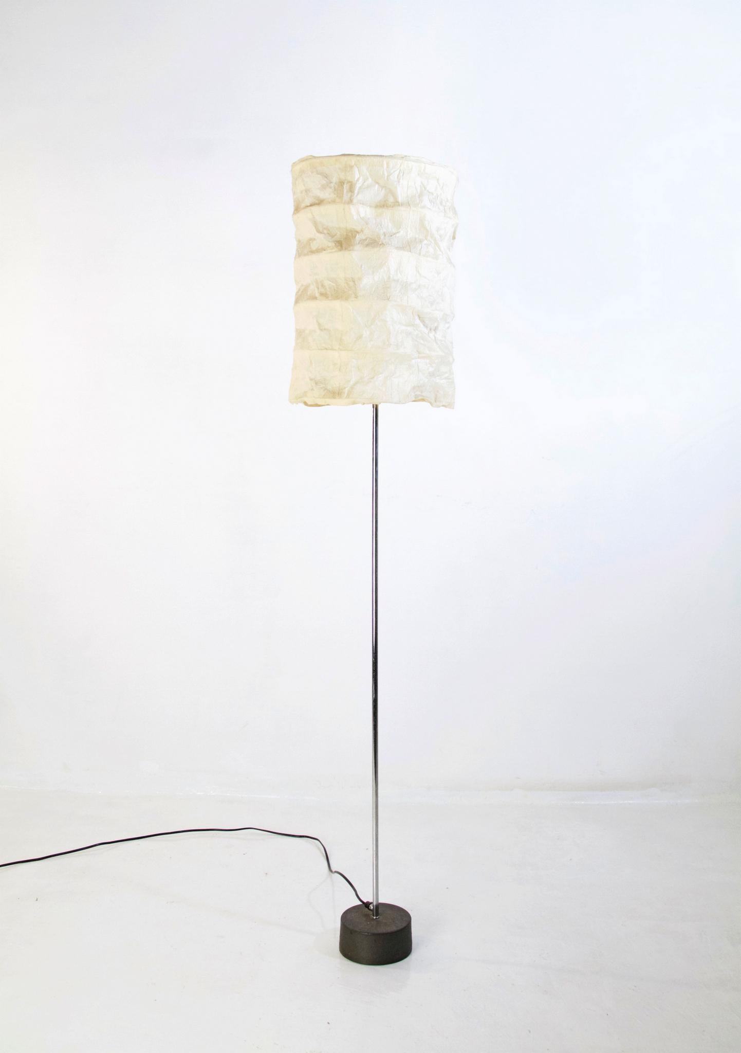 Midcentury floor lamp in a clean and elegant design with a base in cast iron and a chrome stem. On top sits an offwhite lampshade in patchwork. Light is turned on by pulling a chain. All original and in good condition.