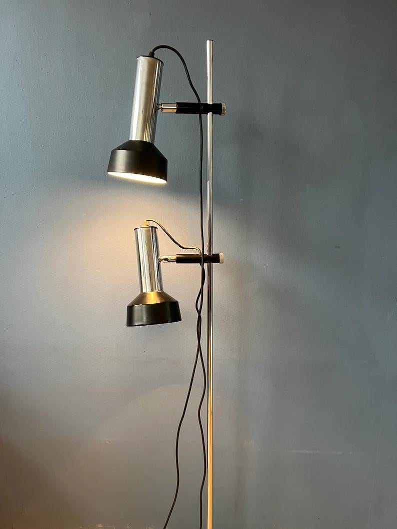 Lampada da terra della metà del secolo scorso, molto robusta, con due bellissimi spot in cromo e nero. La lampada richiede due lampadine E26/27 ed è attualmente dotata di una spina UE (facilmente utilizzabile al di fuori dell'UE con un convertitore