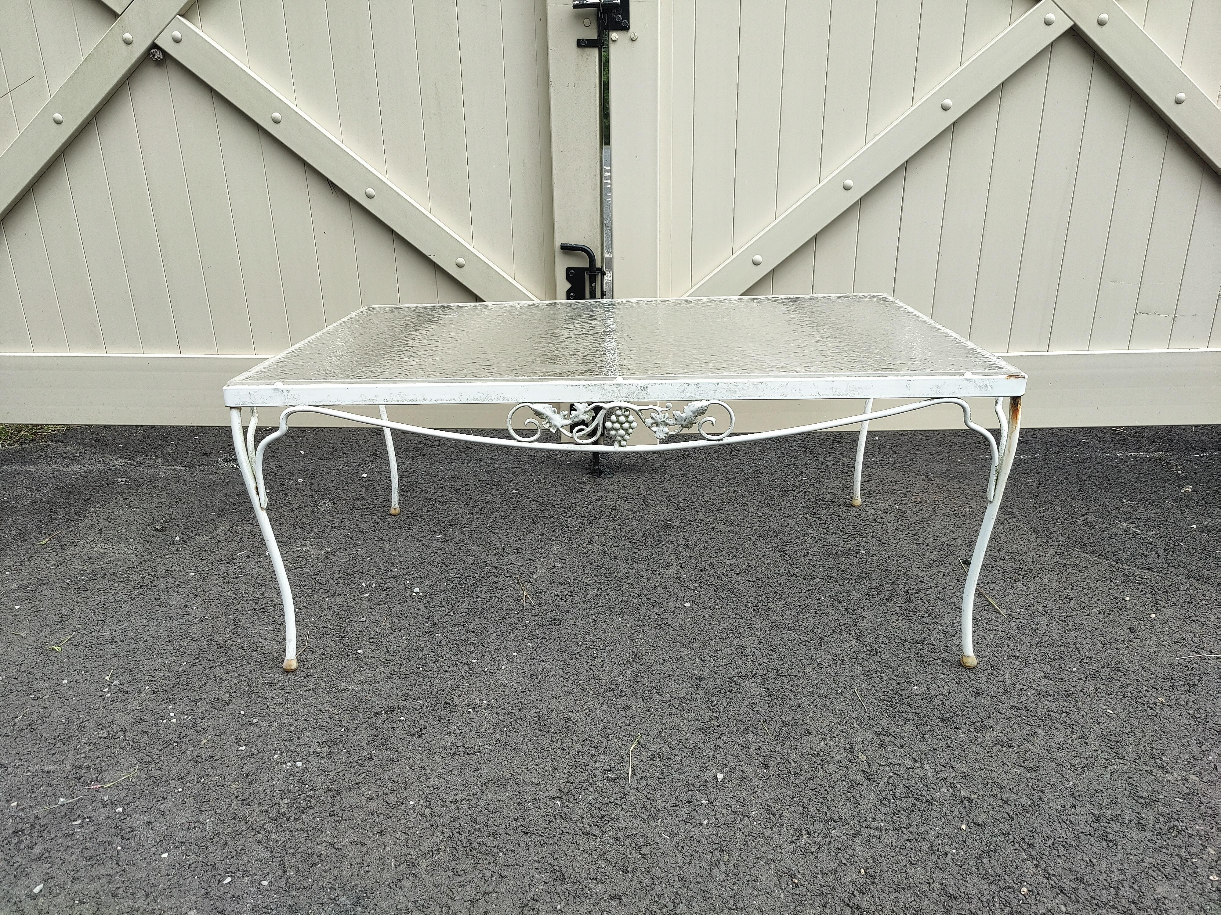 Mid-century Floral patio table. Made out of sturdy wrought iron with a plexi glass top. This table features elegant scrollwork and floral designs, Perfect for any patio, pool, balcony setting.

(Please confirm item location - NY or NJ - with