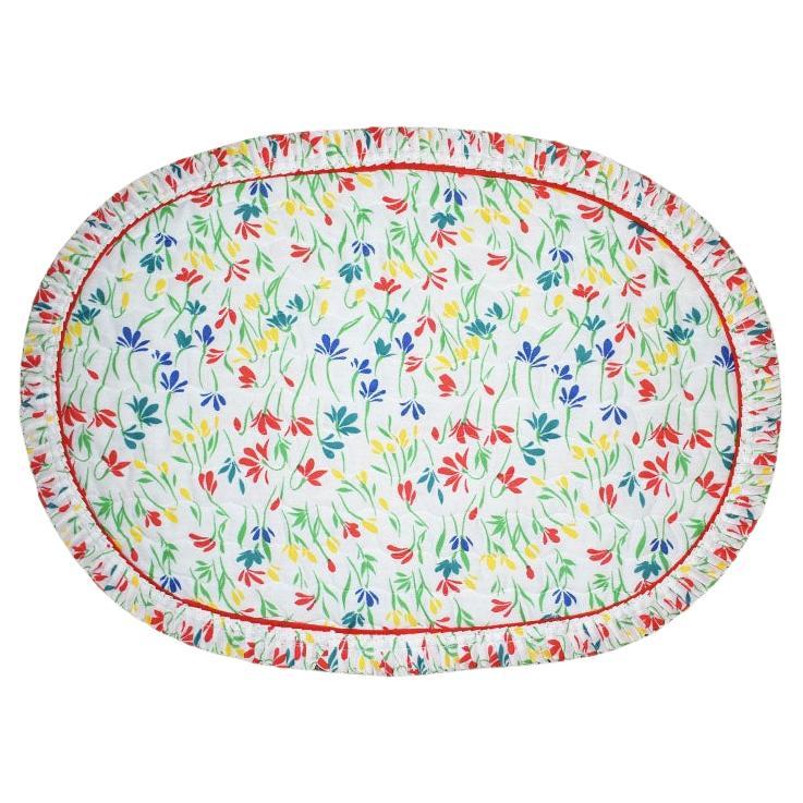 A set of four mid-century modern placemats and matching napkins. A fantastic way to add a cheery pop of color to a place setting! The placemats are created from a floral quilted fabric in the colors red, blue, green, and yellow. The edge of each mat