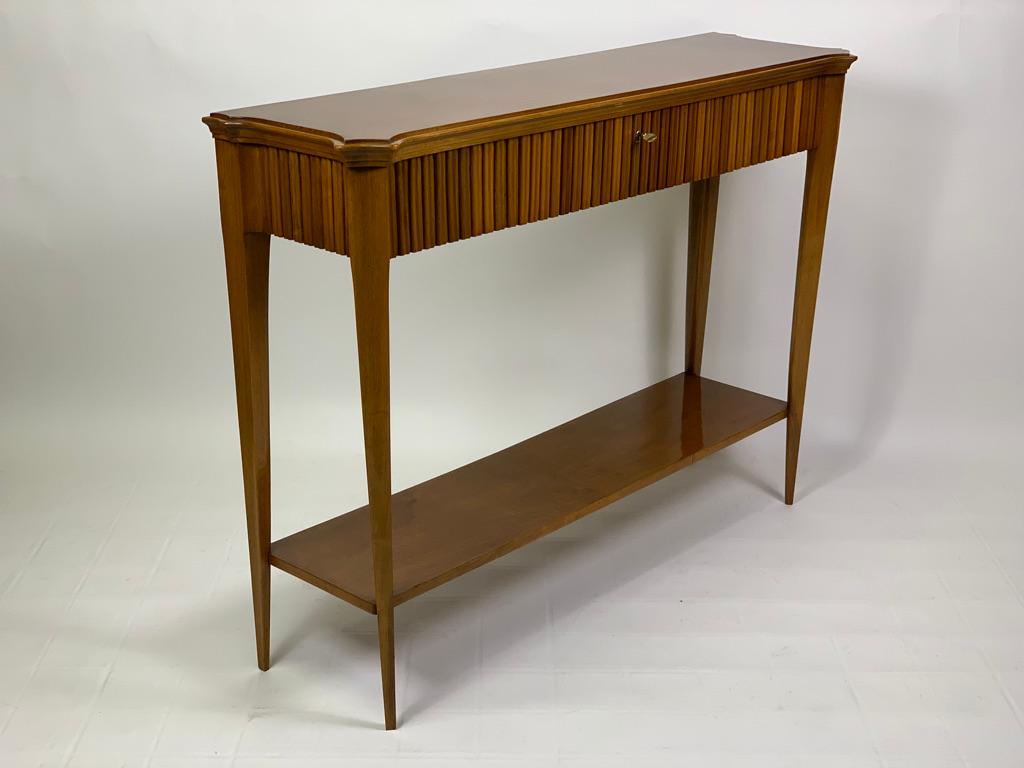 This one of a kind console in solid walnut carved made in Florence Italy in the late 40s and designed by the architect Italo Gamberini for a Florentine residence, stands out for its elegance and practicality, very warm color of the precious