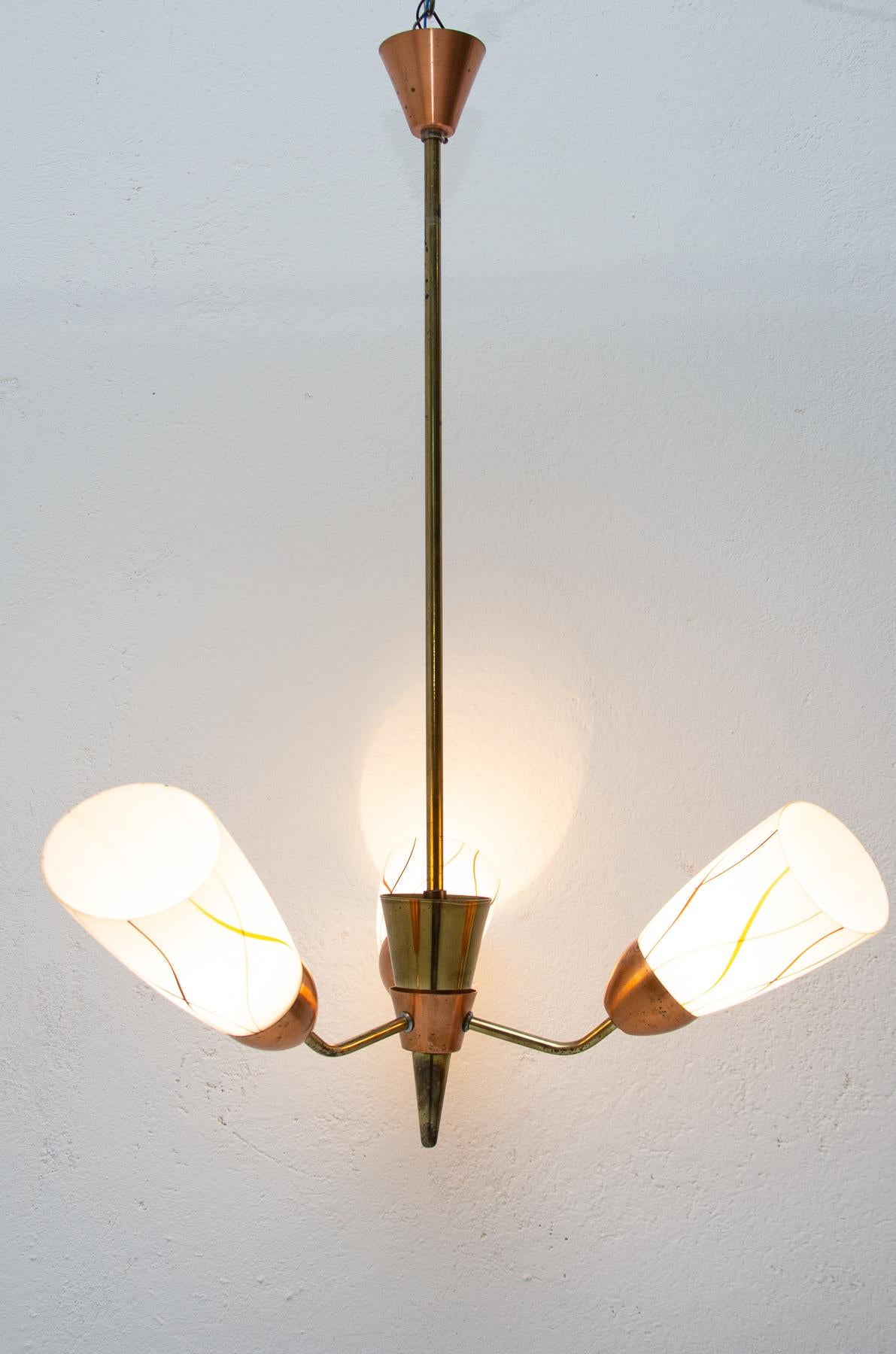 Midcentury copper and milky glass pendant lamp in the shape of the bloom, it was made in Czechoslovakia in the 1960s. In good condition, new wiring, slight signs of age and using

Measures: Lampshade height 20 cm.