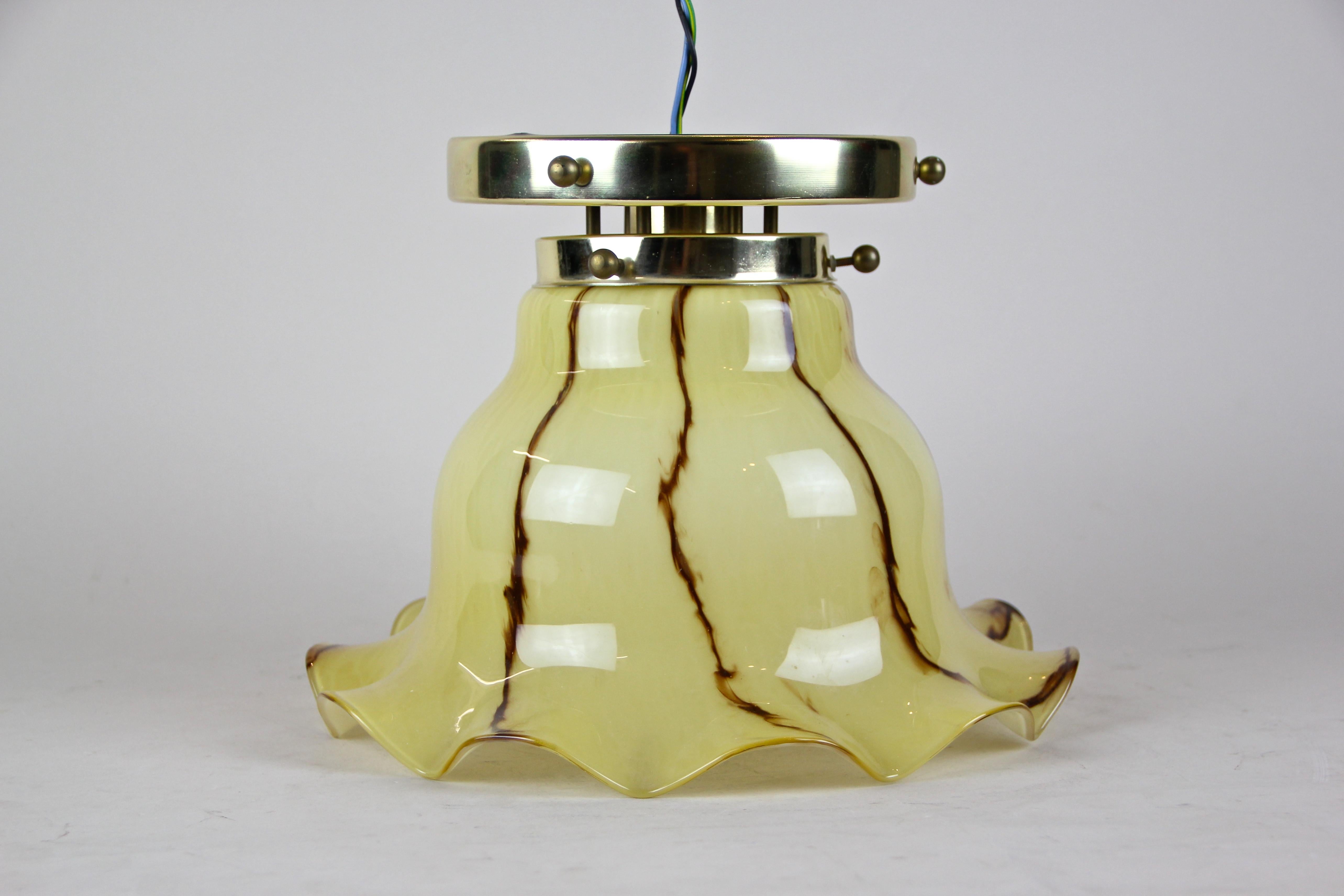 Beautiful midcentury flush mount lightning from Austria, circa 1950. The lovely lamp impresses with the original large frilly glass lampshade colored in yellow/ beige tones, crisscrossed by brown lines. A real nice piece of a midcentury lighting.