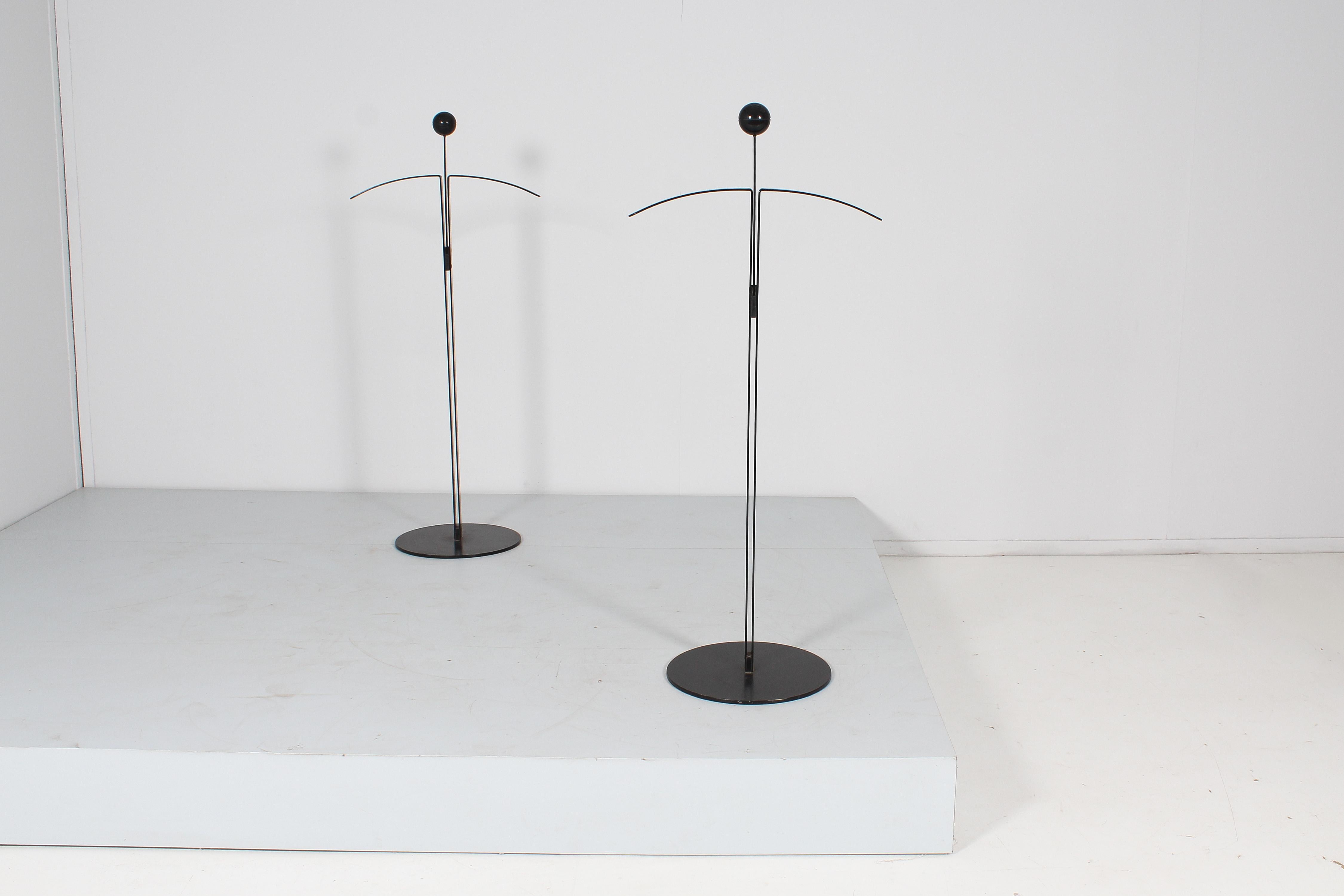 Stylish pair of coat racks - valet stand in black lacquered metal with arrow curved at the top and additional support rod with ball from vertical to horizontal with joint. Production by Fly Line, Italy in the 70s. Factory label glued to the