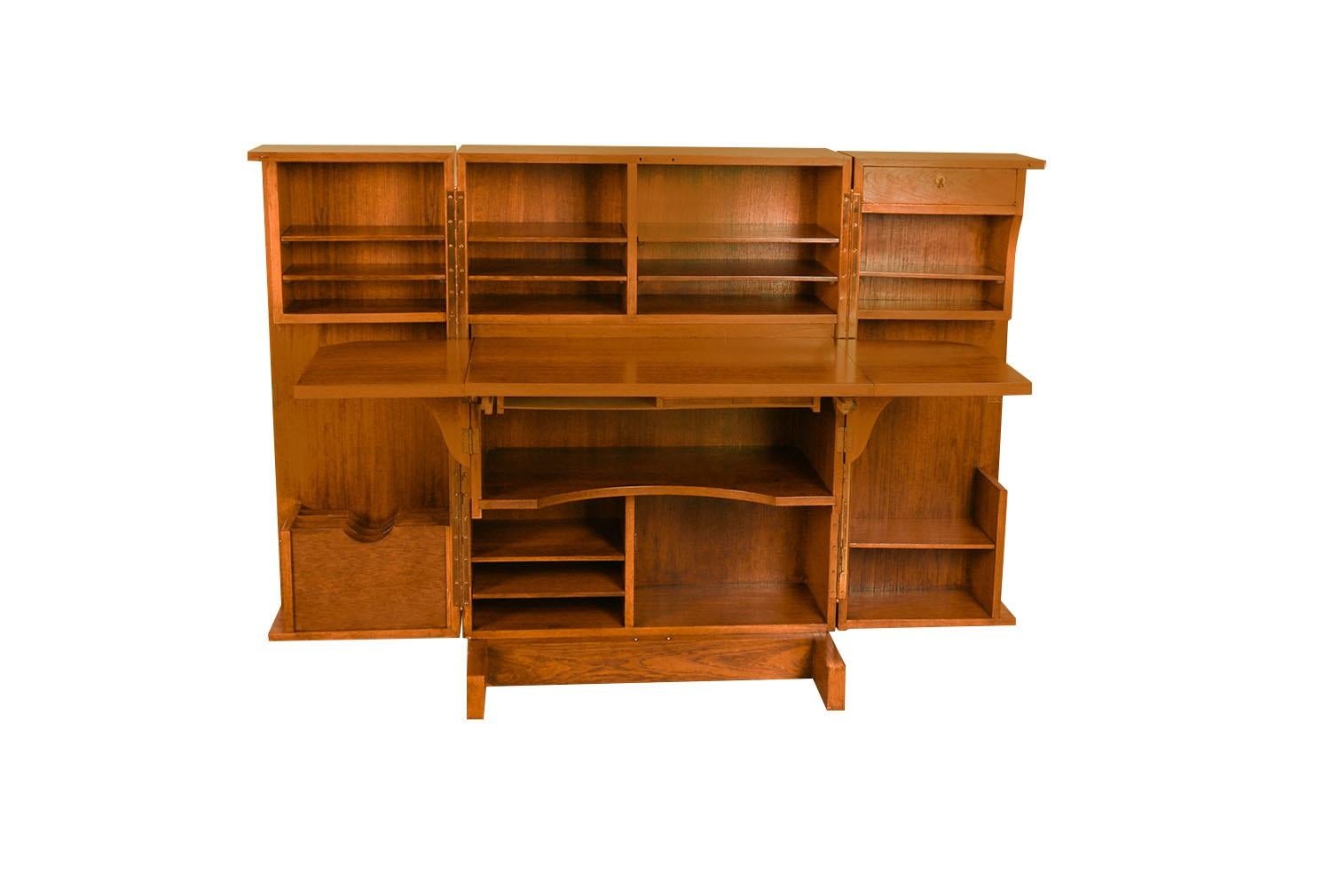 A desk with incredible form and presence. This attractive original magic box desk, cabinet/desk made in Denmark, features a brass hinged double door cabinet that opens up to reveal  an  abundance of storage space and cubbies with adjustable