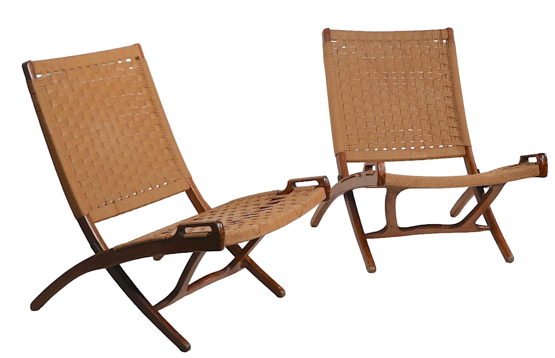 Exceptional pair of folding lounge chairs, Made in Yugoslavia, after the iconic Wegner masterpiece. The chairs are in very fine, clean, original, and ready to use condition, showing only light cosmetic wear, normal and consistent with age, specific