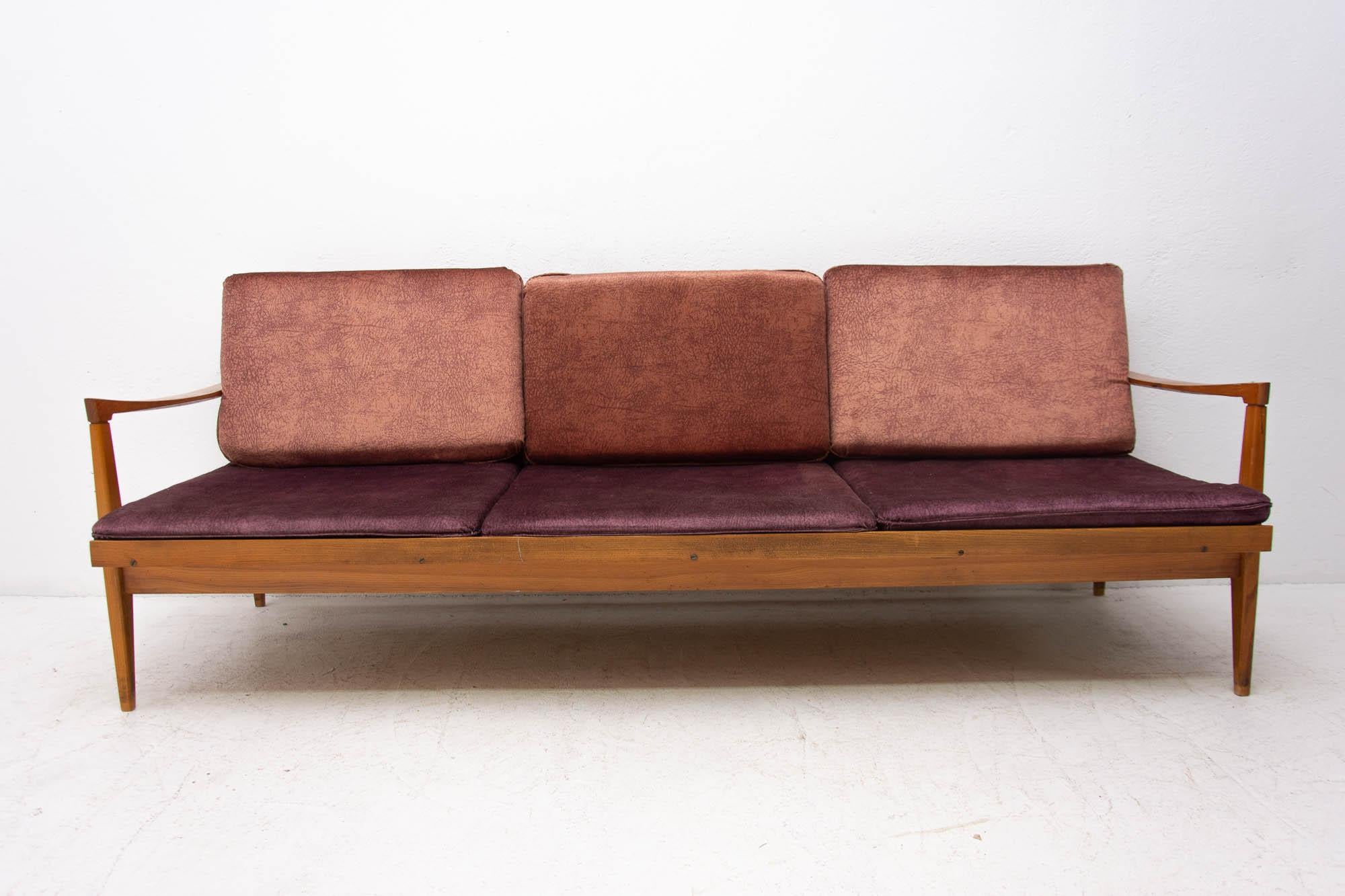 Midcentury sofa bed in Scandinavian style. It was made in the former Czechoslovakia in the 1970s. This sofa features wooden structure that is veneered in beechwood. The sofa is in very good condition.