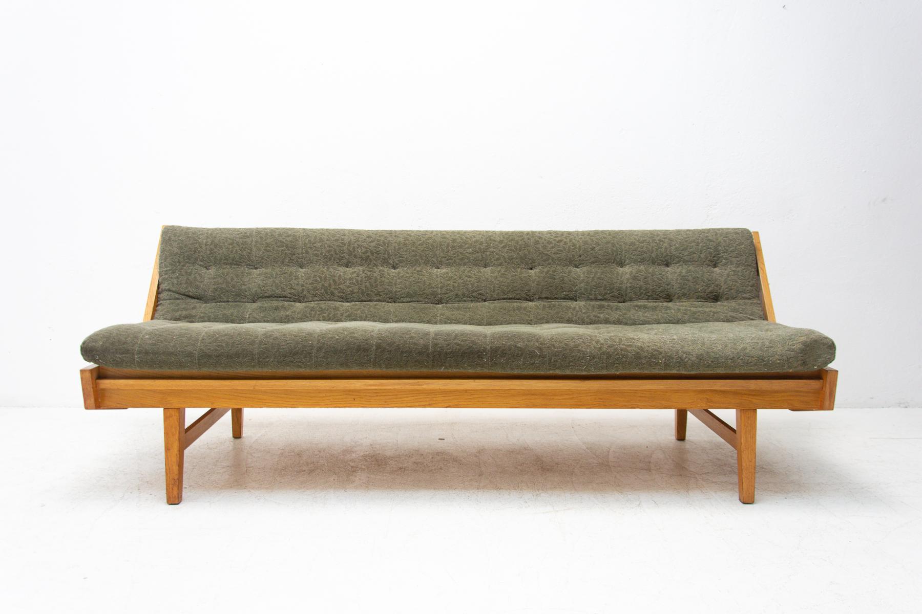 Mid century sofabed, made in the former Czechoslovakia in the 1960´s. This sofa features a wooden structure that is veneered in oak. The sofa is in very good original condition, shows slight signs of age and using.

Measures: Unfolded: 182 x 80