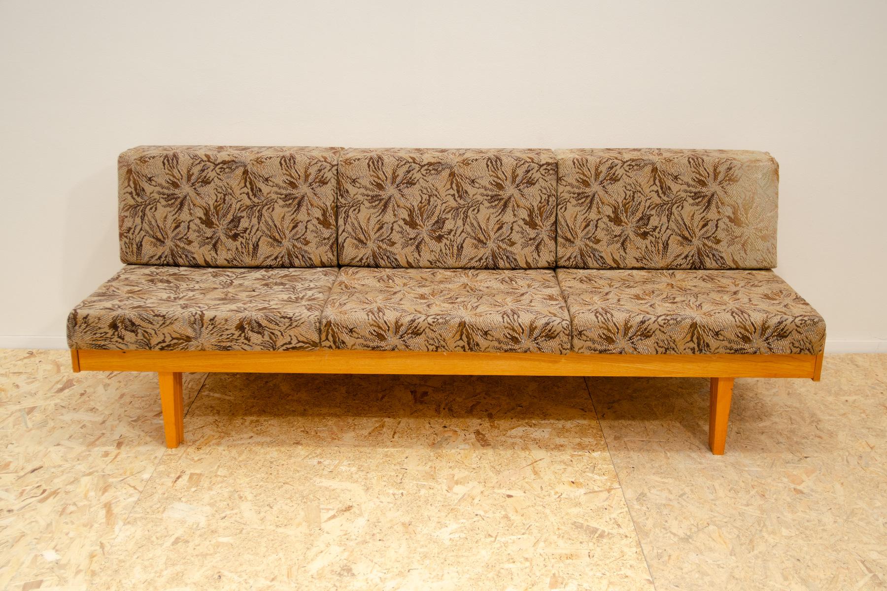 Mid century sofabed in Hans Wegner style, made in the former Czechoslovakia in the 1960´s. Material: beech wood, fabric. The sofa is structuraly in very good condition, the fabric is completely faded from the sun in several places. It would be