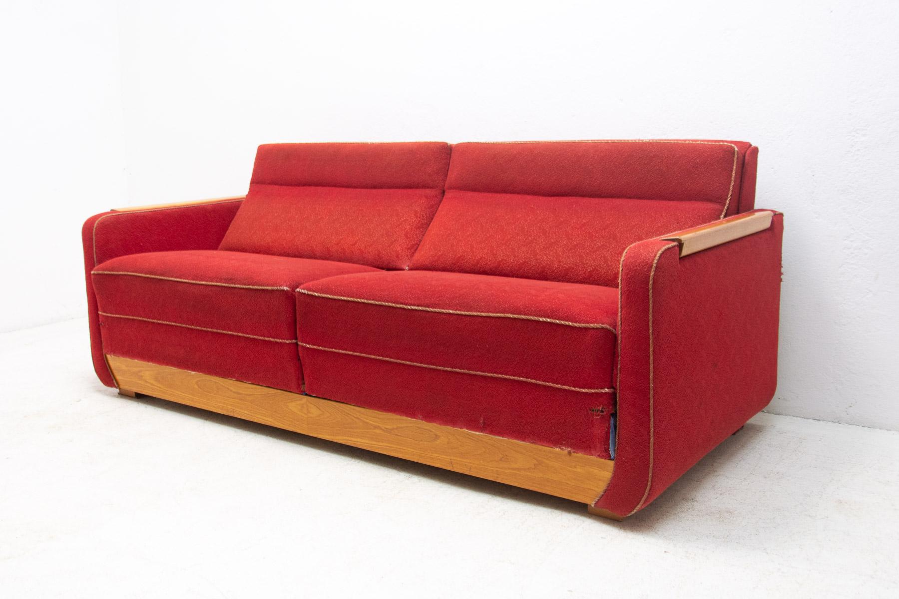 Vollständig gepolstertes modernistisches Sofa mit ausziehbaren Tischen, 1950er Jahre.
Dieses Sofa wurde in den 1950er Jahren in der ehemaligen Tschechoslowakei hergestellt. Es trägt die Handschrift von Jindrich Halabala, könnte aber auch von einem