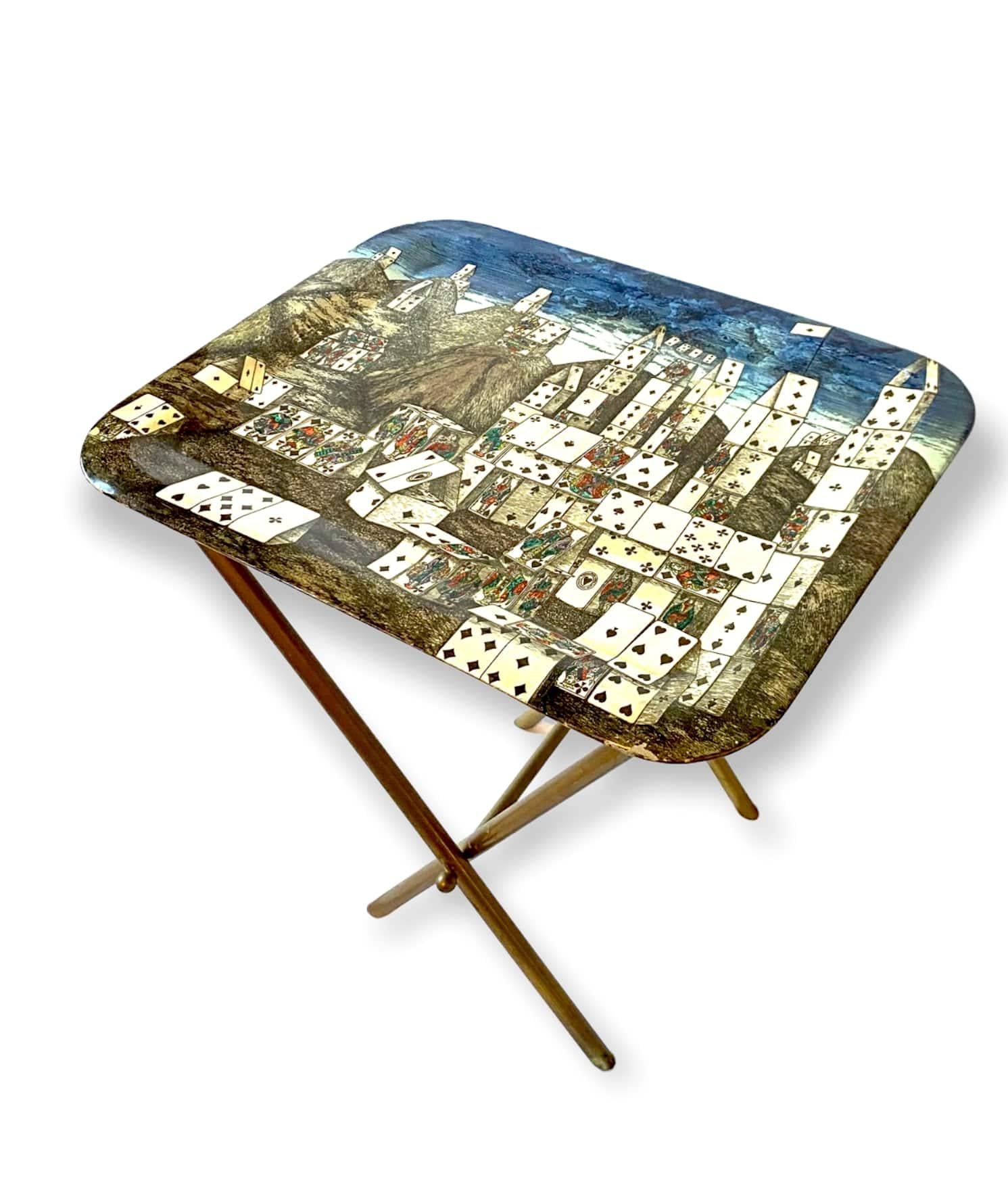 Midcentury folding coffee table.

Fantasia “Città delle Carte” (City of Cards). The rarest and most fascinating Fornasetti’s pattern.

Piero Fornasetti, Italy, 1950s

French label under the tray (1955 - 1965)

Brass, fabric,