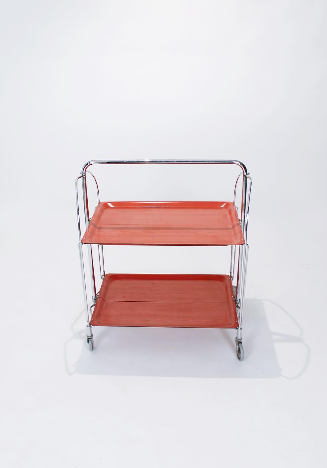 This serving trolley can also be used as a side table, when half folded.
In fine, well-functioning condition.
The frame is made of chrome-plated tube, the panel is made of Resopal. Chrome-plated castors, Versatile living room accessory. In good