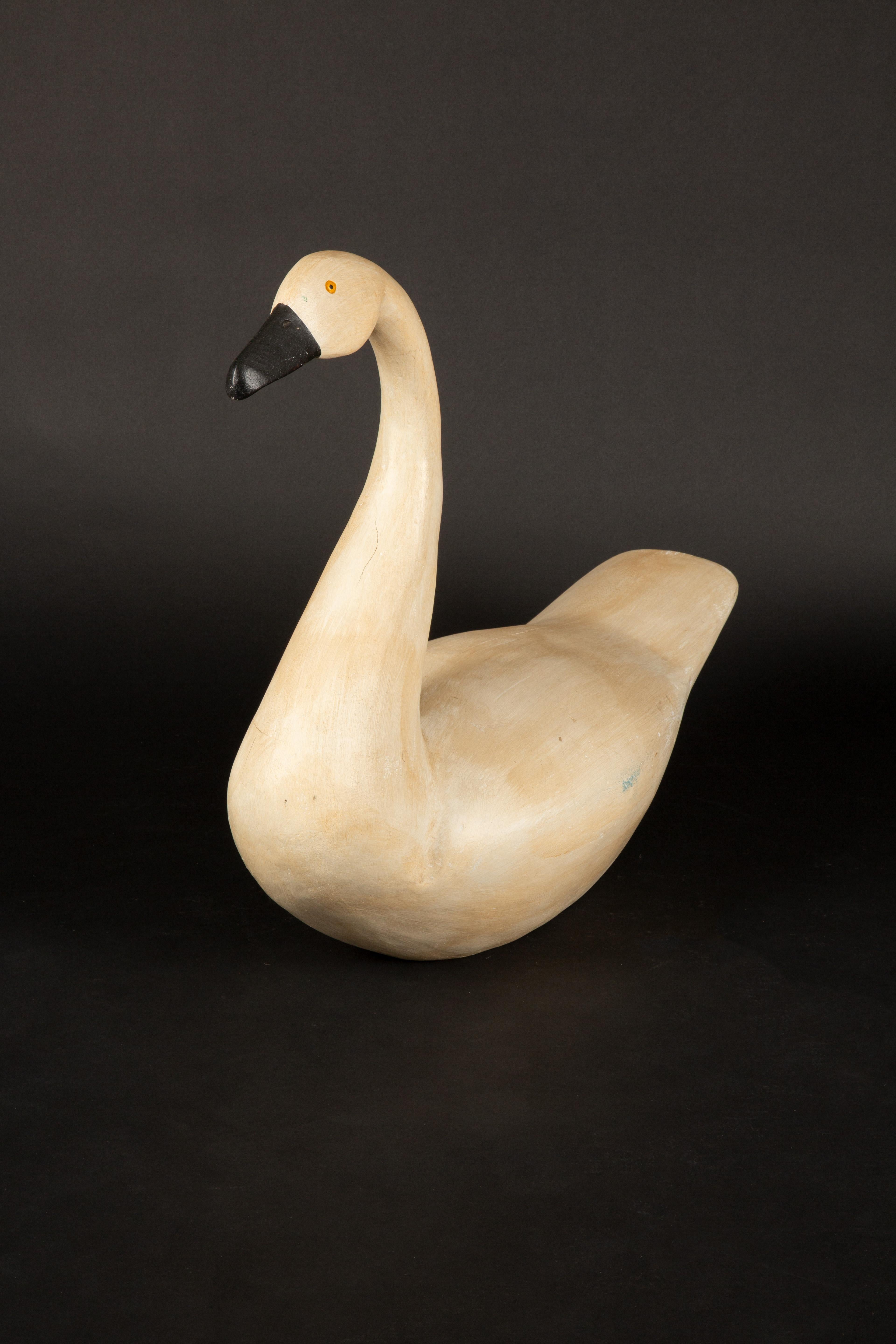 Questa esca cigno del XX secolo incarna lo spirito dell'arte popolare americana. Realizzato da un intagliatore anonimo, presenta un collo splendidamente allungato e un corpo quadrato e robusto. Le curve dolci e il design minimalista catturano