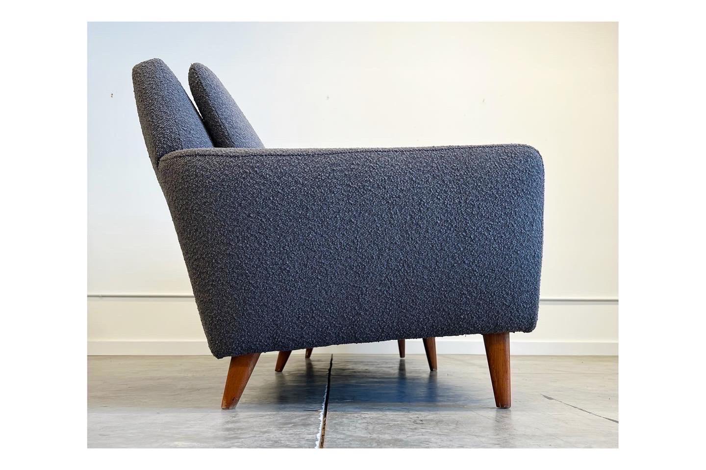 Modern with clean lines describes this mid century sofa designed by Folk Ohlsson for Dux. We reupholstered the sofa in a slate gray bouclé to update it for the modern home. It seats four and deserves to be enjoyed. Original tag.