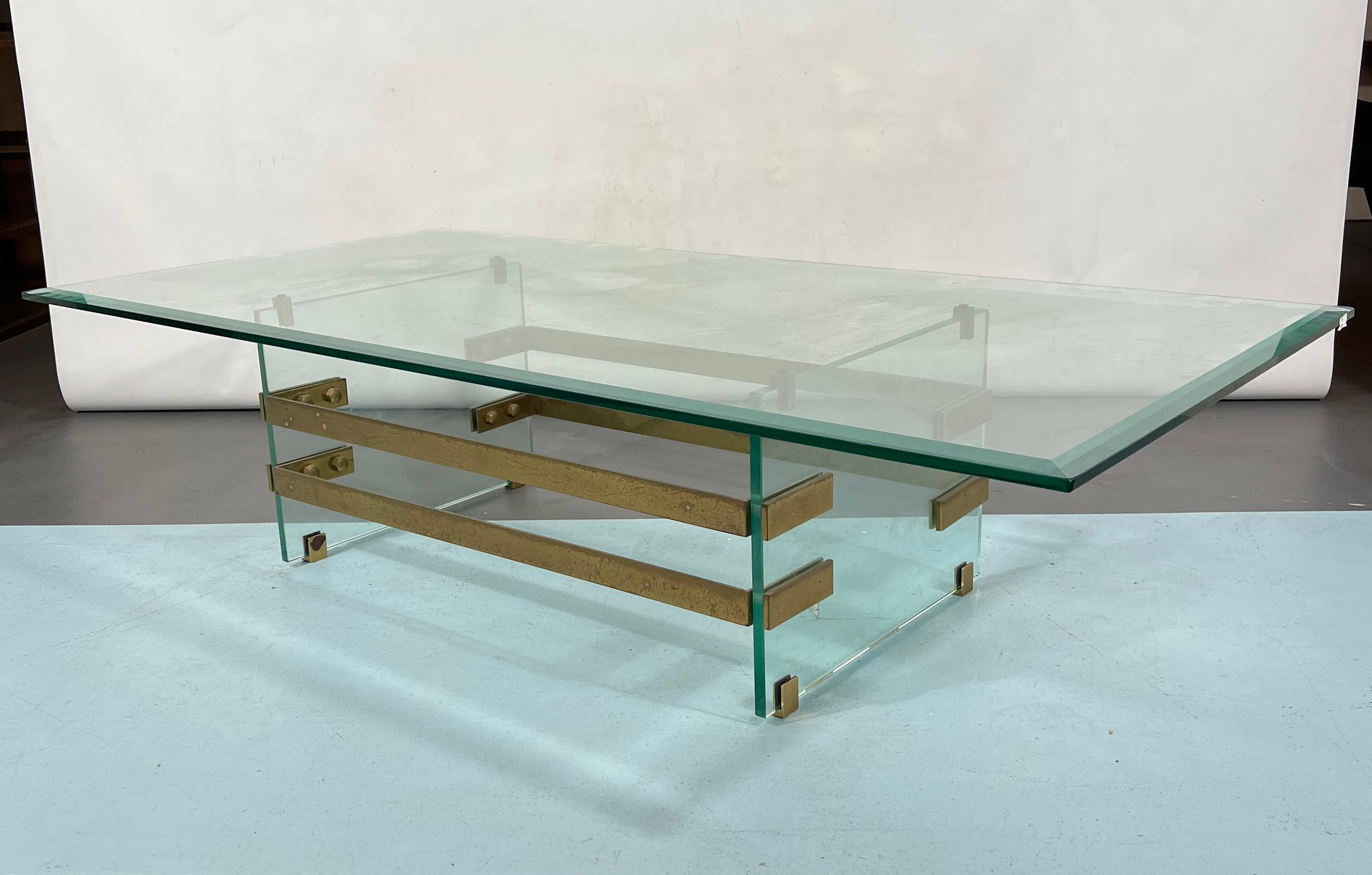 Good vintage condition with trace of age and use for this coffe table made from solid brass and thick glass. Attributed to Fontana Arte and produced in Italy during the 70s. Original patina on the brass.