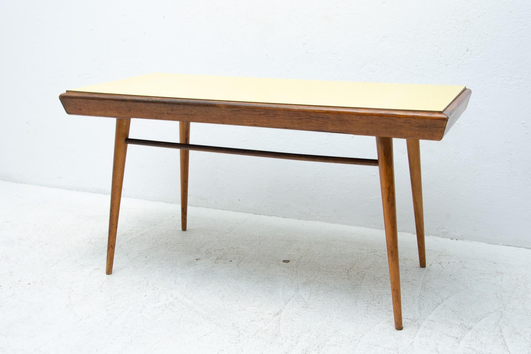 Mid century opaxite glass coffee table from the 1960´s. Associated with the world-renowned exhibition EXPO 58 in Brussels. It was produced by “Interiér Praha”. It features a beechwood construction and formica tabletop in two different color. In good