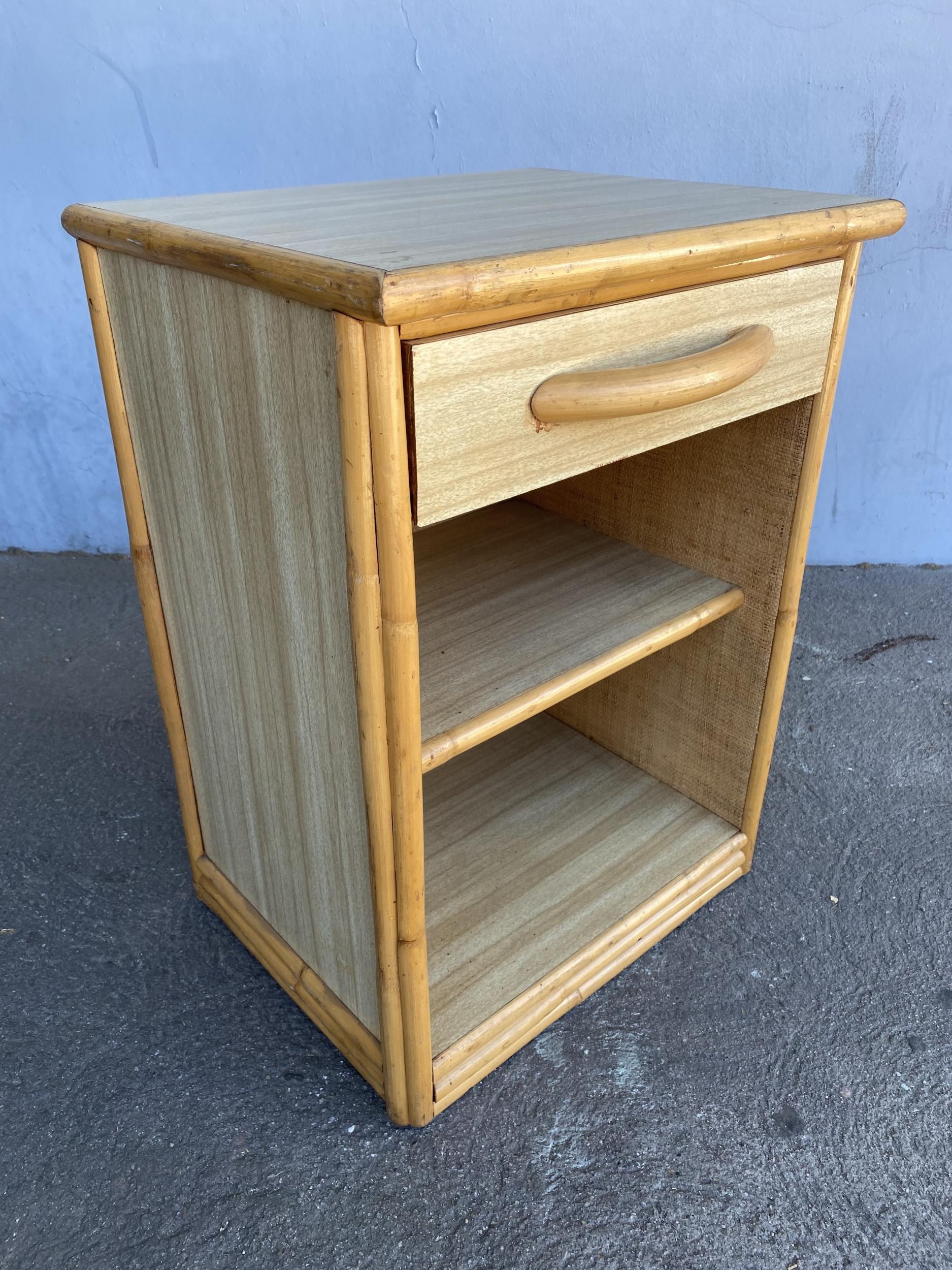 Original 1950s Formica and rattan nightstand with a rattan border, Formica sides, and top with a steam-bent rattan pull handle.

Designed in the manner of Paul Frankl.

Restored to new for you.

All rattan, bamboo and wicker furniture has been