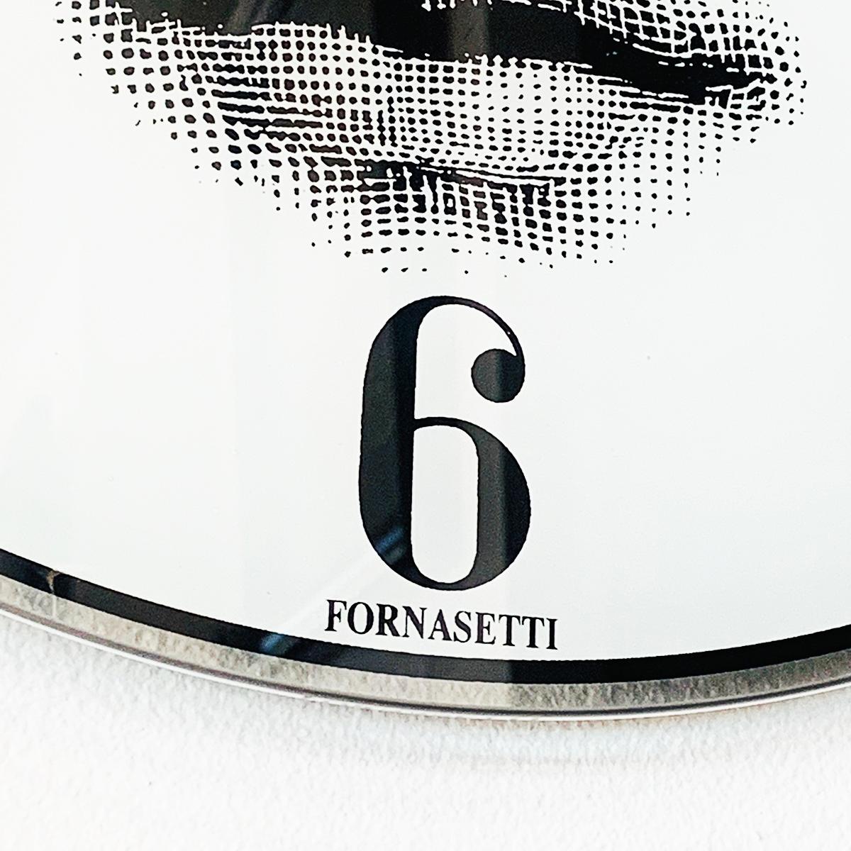 Midcentury Fornasetti wall clock with the face of 19th century operatic soprano Lina Cavalieri, Arabic Numerals, and “FORNASETTI” below the 6 position, all in black with white background. Solid glass face with filigree hands. Quartz/battery marked