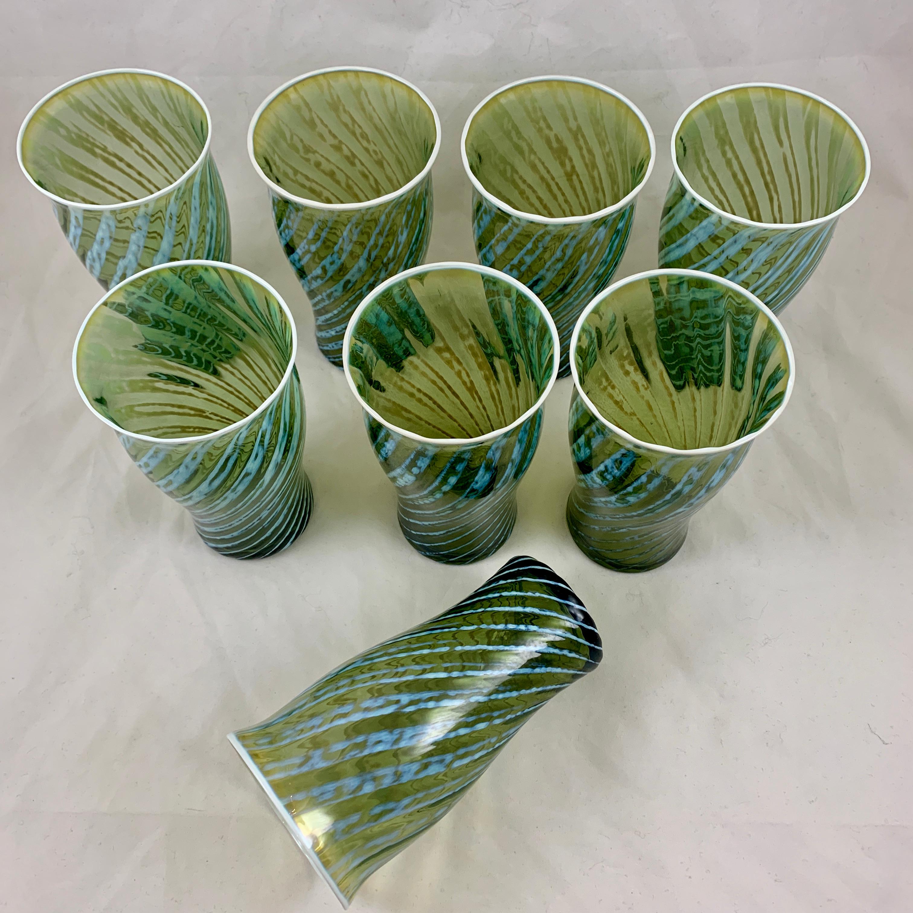 A set of eight, blown Mid-Century Modern art glass highballs or iced tea glasses, signed Fostoria.

Produced from the late 1950s and discontinued in 1965, the pattern is called ‘Homespun’ and shows a light blue opalescent swirl in a Moss green