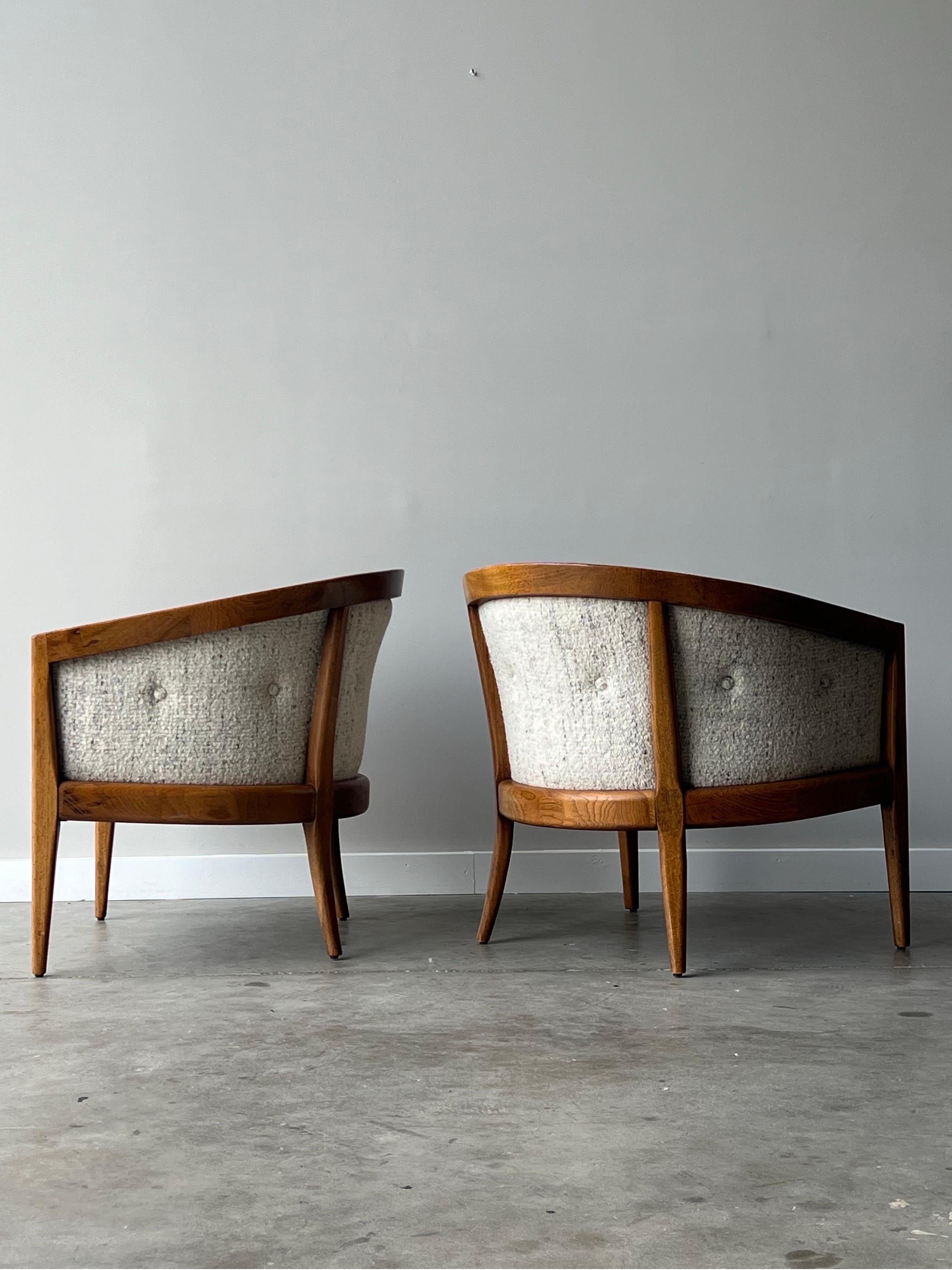 A pair of mid-century lounge chairs by Founders. This pair has so much to offer. Sculpted walnut wraps around the back of the chair contouring the rounded back. The walnut has a warm and vibrant wood grain. The chairs sit on tapered walnut legs. The