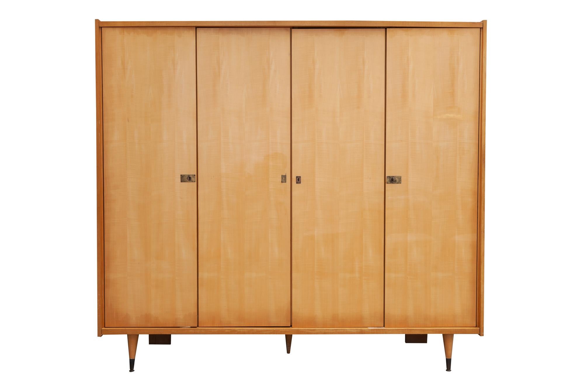 1950s wardrobe, France. Glossy blonde wood with four doors with key and brass-capped spindle feet. Hanging space in every compartment. Easily assembled or disassembled with screw lock clips.
Add a touch of charm and elegance to your home with this