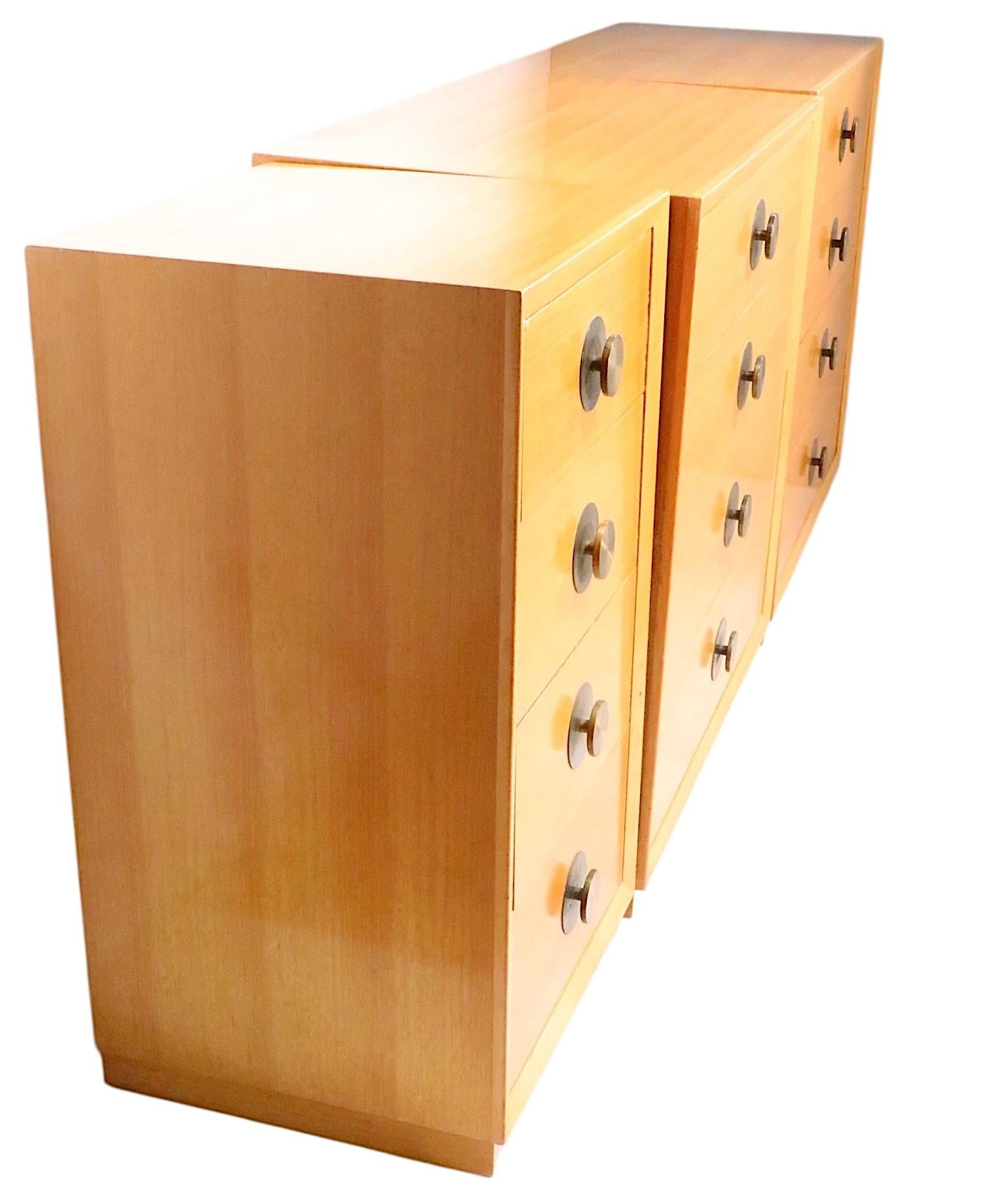 Chic table de nuit ou commode à quatre tiroirs, en placage blond d'origine, avec au centre des poignées en forme de disque en laiton. La table de nuit est en bon état, d'origine et intacte. Elle présente quelques petits défauts cosmétiques et