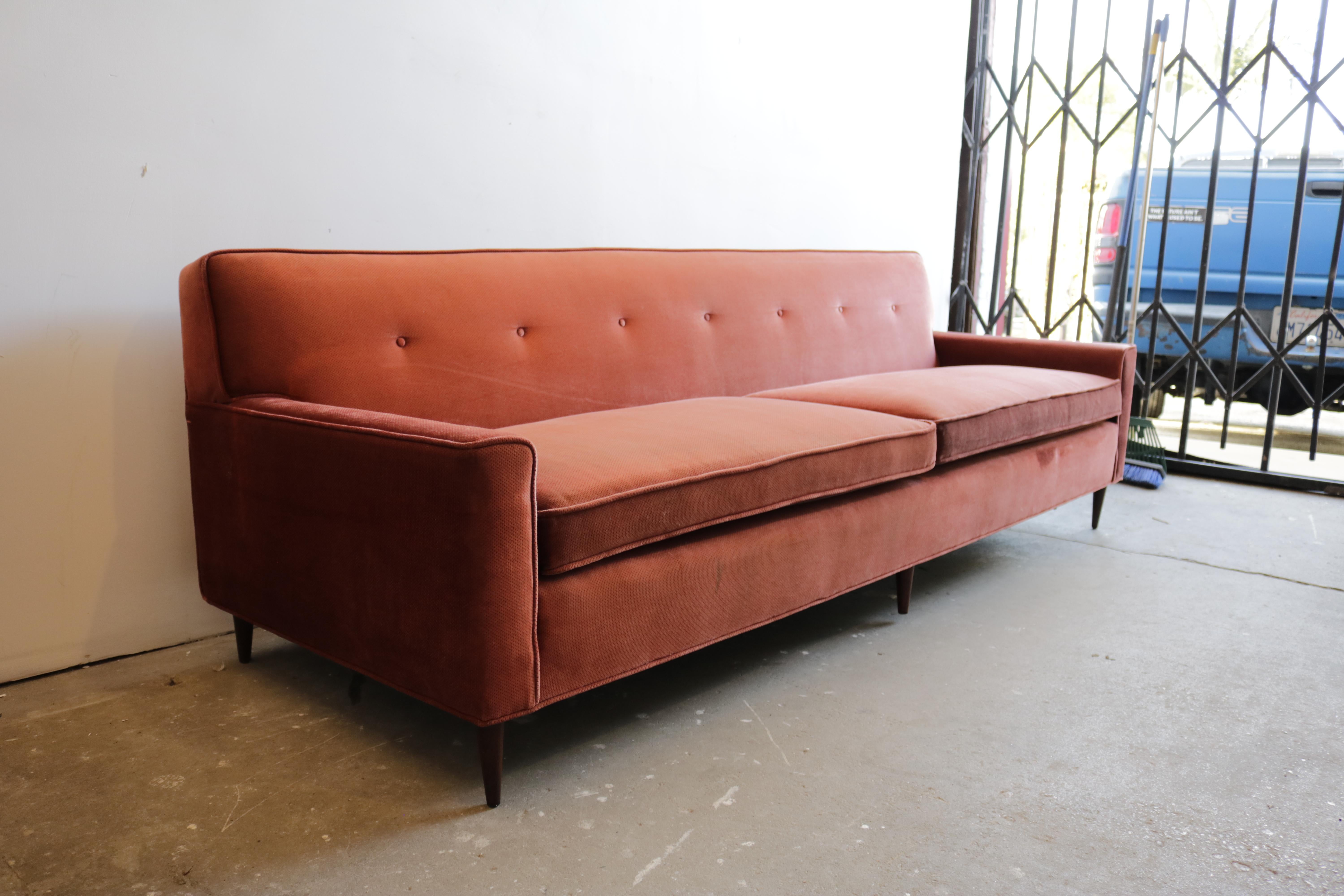 Plain and sleek midcentury sofa with walnut legs.