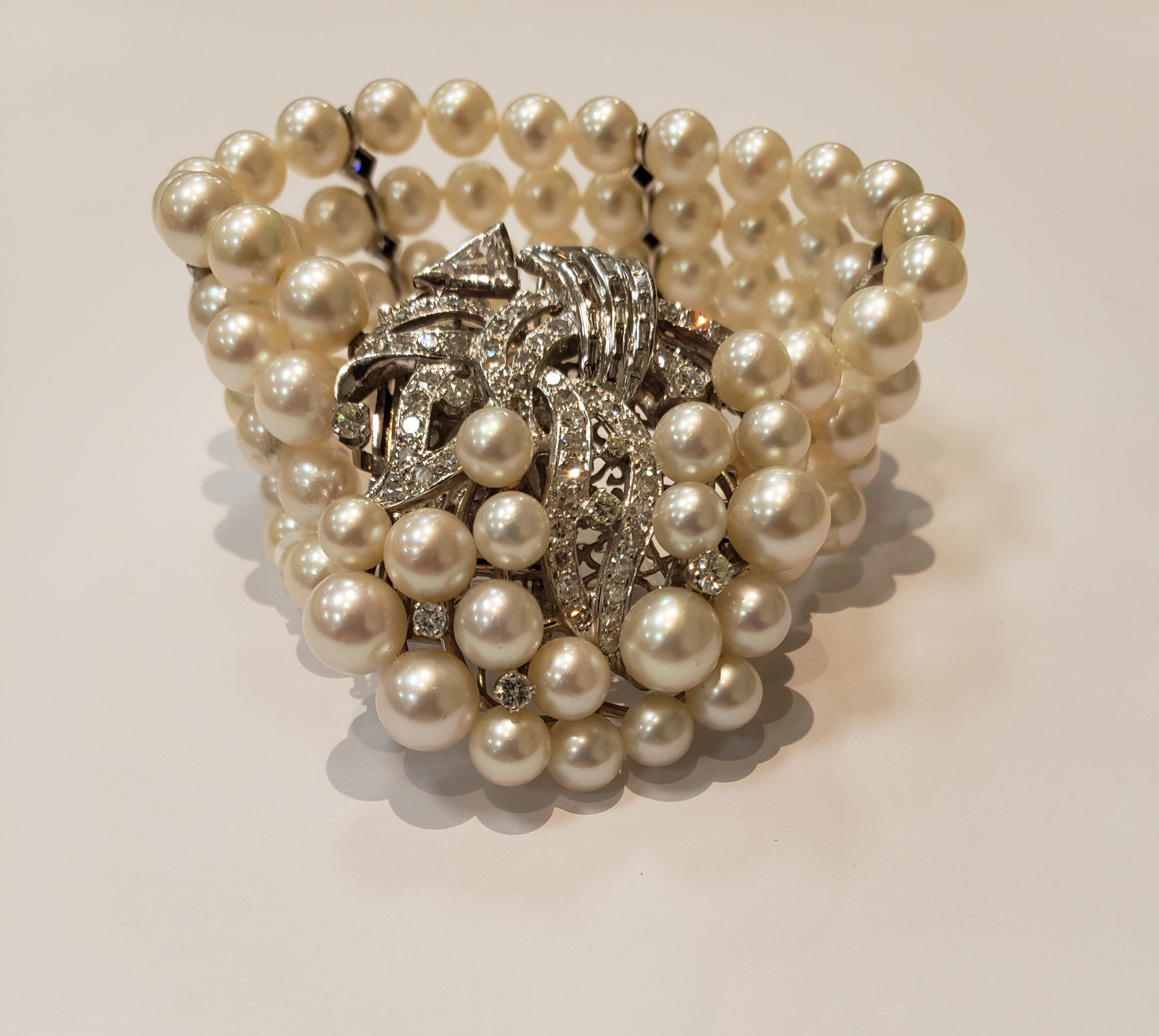 A Four Strand Pearl Bracelet With Four Spacers, Each Containing 3 Small Diamonds. Pearls are 6 Millimeters.
Clasp Has a Spray of 19 Different Size Pearls, and Assorted Diamonds, Including 56 Round, 17 Baguettes & 1 Trapezoid.
Bracelet is 6.25 Inches