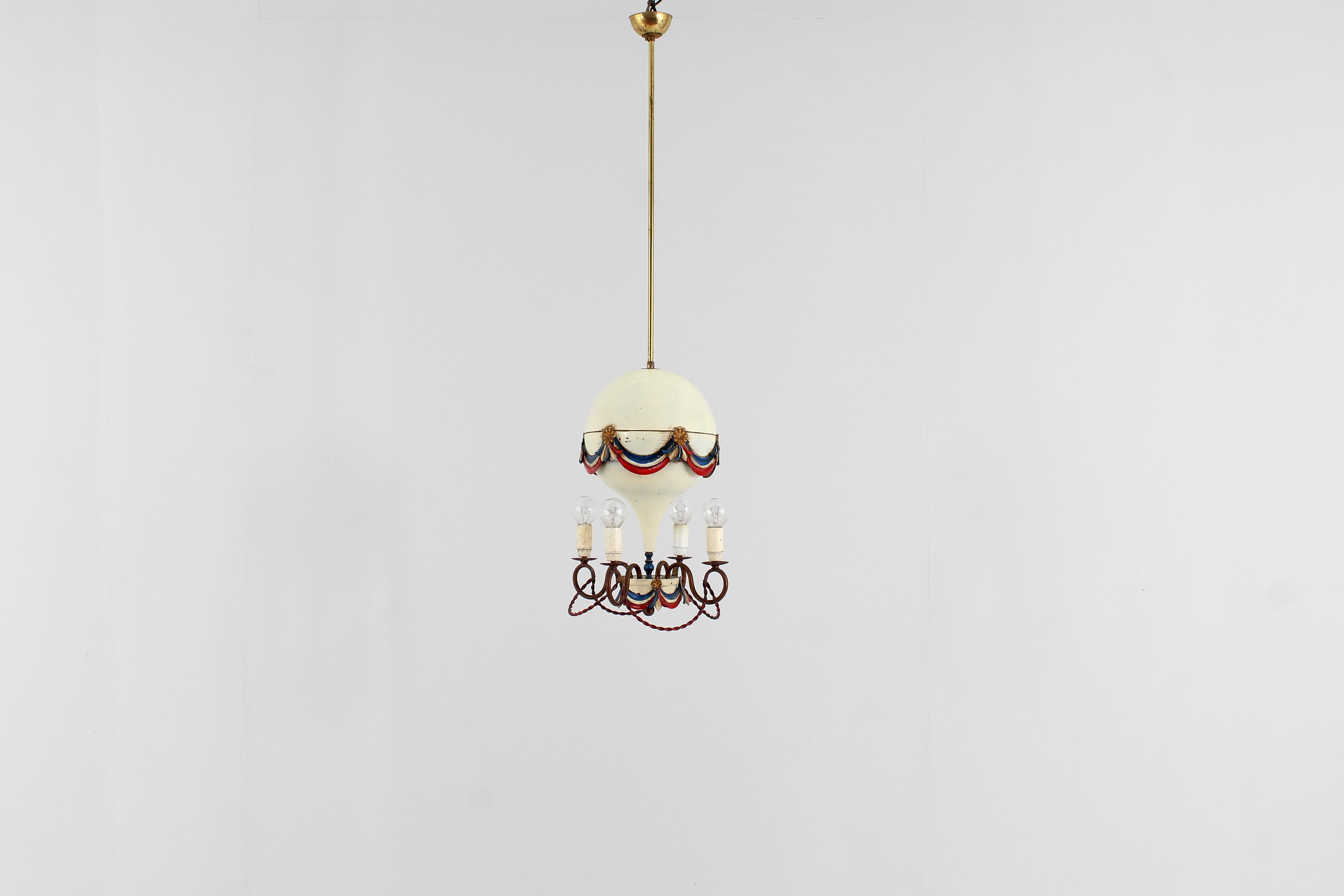 Delicious ceiling lamp ishaped of a hot air balloon. The main body (air balloon) is metal with original hand painted red, white, blue and gold festoons and rosettes
There are four curved brass rod lighting arms, each carrying a single e14 screw
