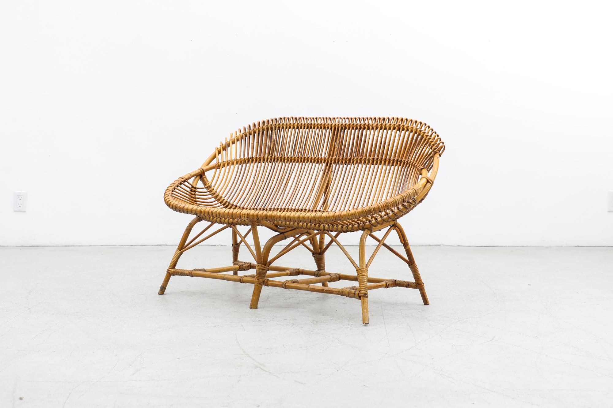 Gorgeous Franco Albini Inspired, masterfully hand-woven Mid-Century Bamboo Love Seat. In Original Condition with Some Signs of Wear Consistent with Age and Use. This piece can be used outdoors under a dry protected and covered area.  A pair of