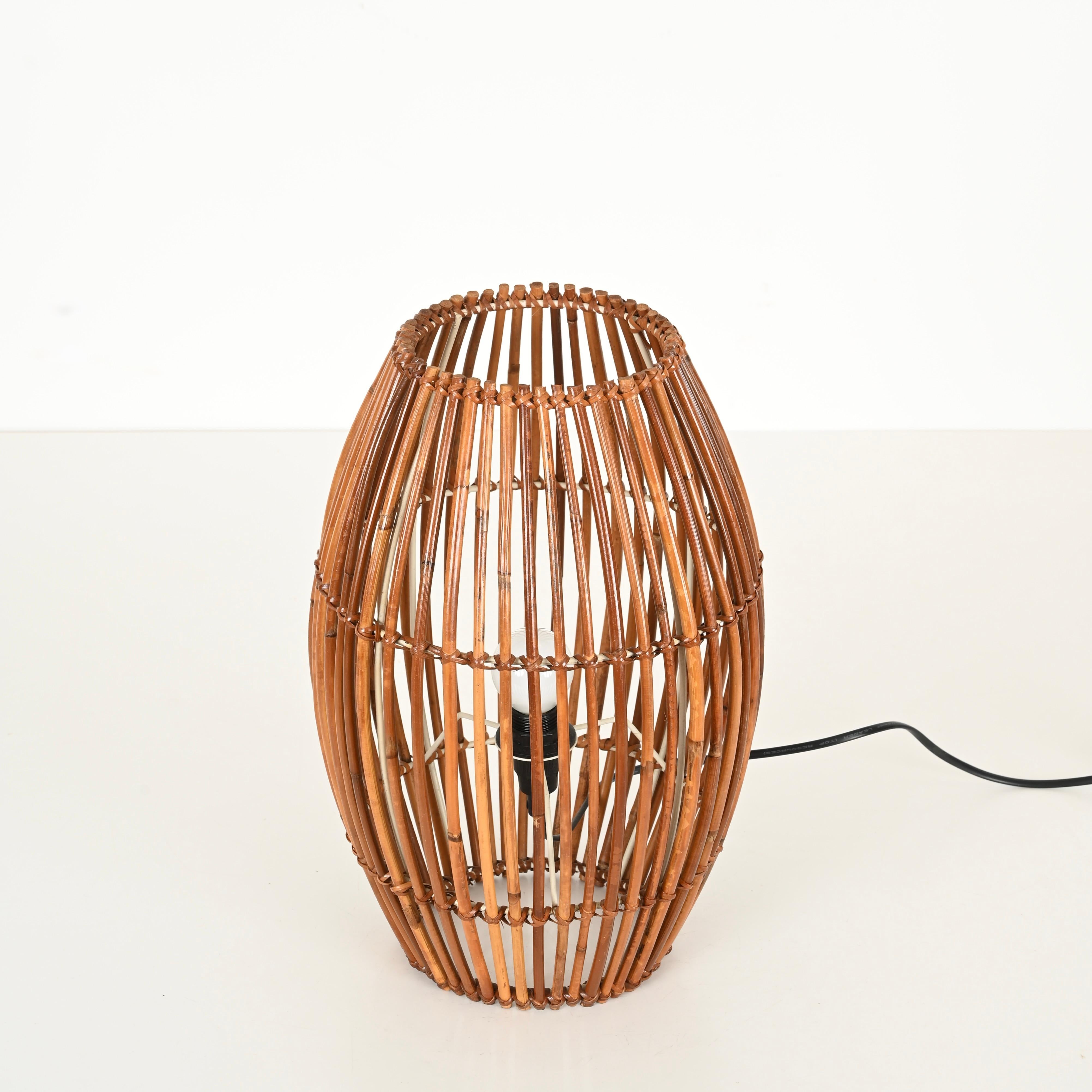 Stunning Mid-Century table lamp entirely crafted from curved bamboo and hand-woven rattan wicker. This stylish and unique organic lamp was designed by Franco Albini and produced in Italy during the 1960s.

In fabulous condition and featuring a