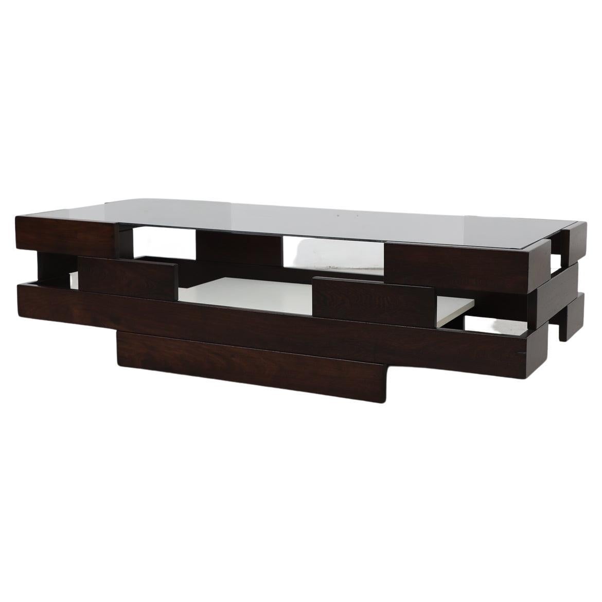 Mid-Century Modern, white laminate shelf, smoked glass top, geometric coffee table with architectural wenge frame. Glass has some wear, such as chips and scratches, and is in its original state. There is one long 1.5