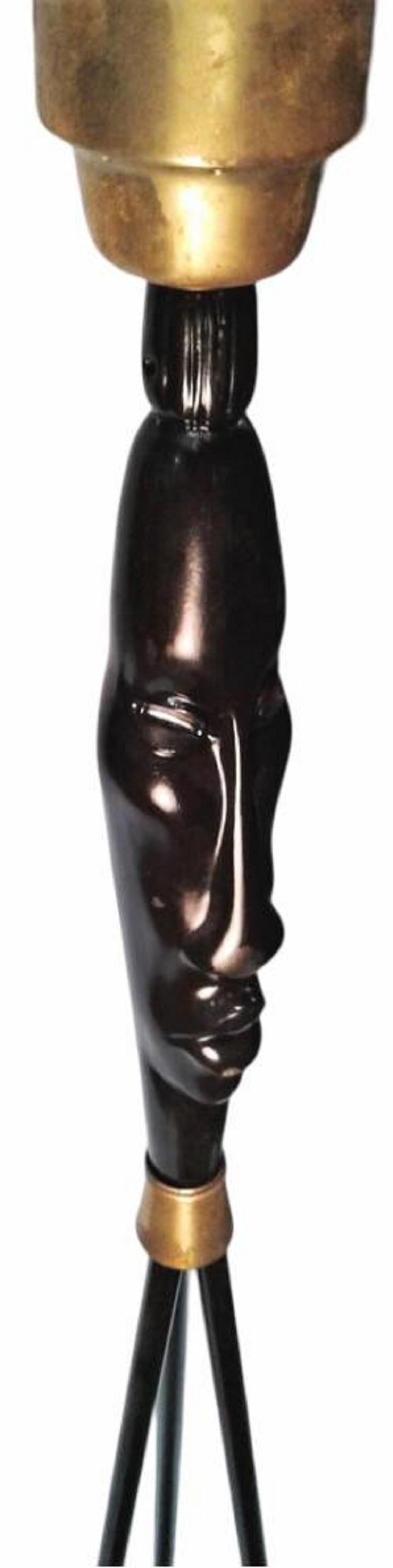 Questa rara lampada di Frederic Weinberg Modern del 1940 presenta un ornamento in ceramica a forma di testa di tiki, fondendo il design moderno della metà del secolo con l'arte di ispirazione polinesiana. Realizzato con una struttura a fuso in