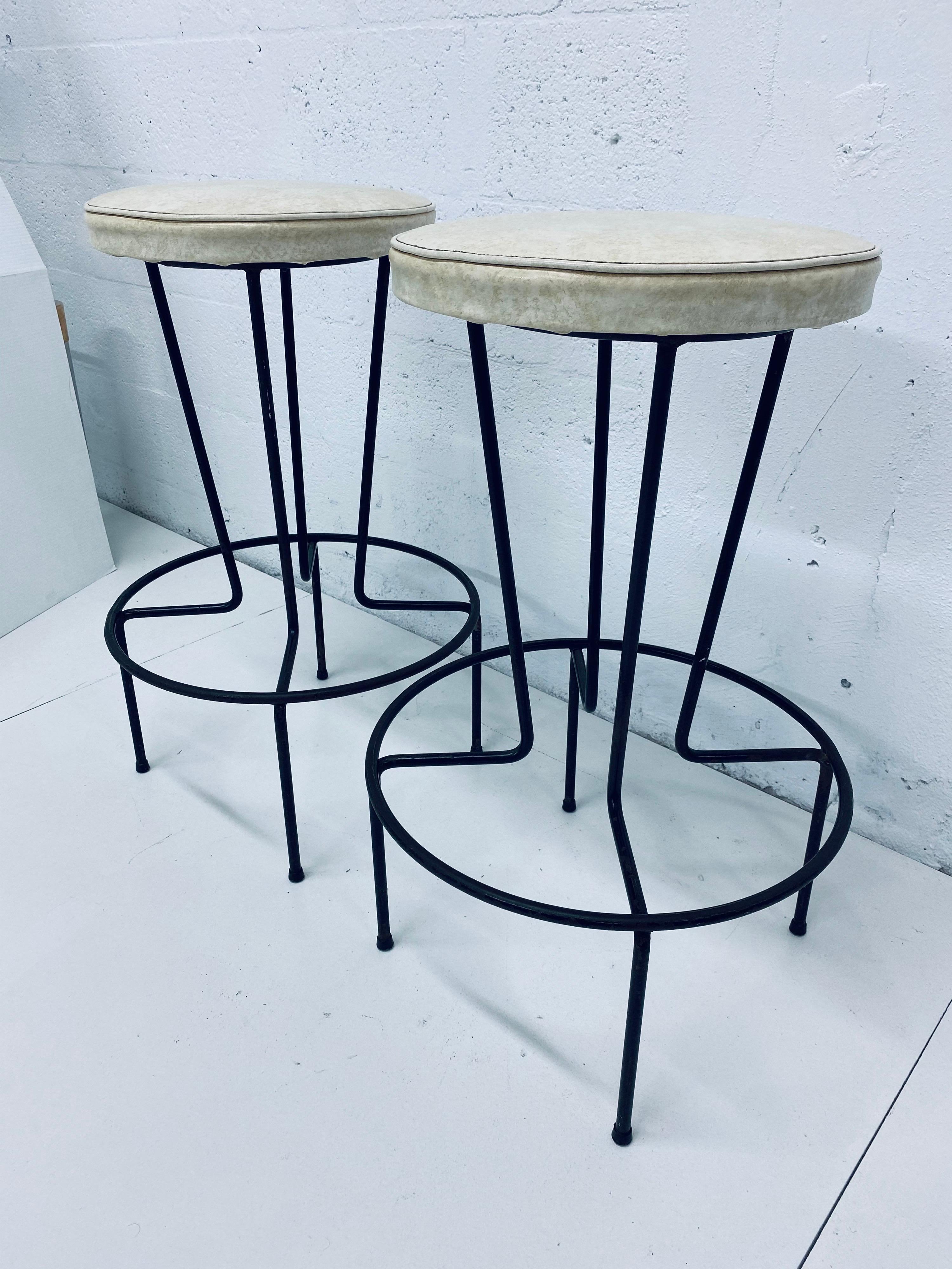 Pair of vintage Frederick Weinberg wrought iron stools with original vinyl fabric. Use as is or have reupholstered.