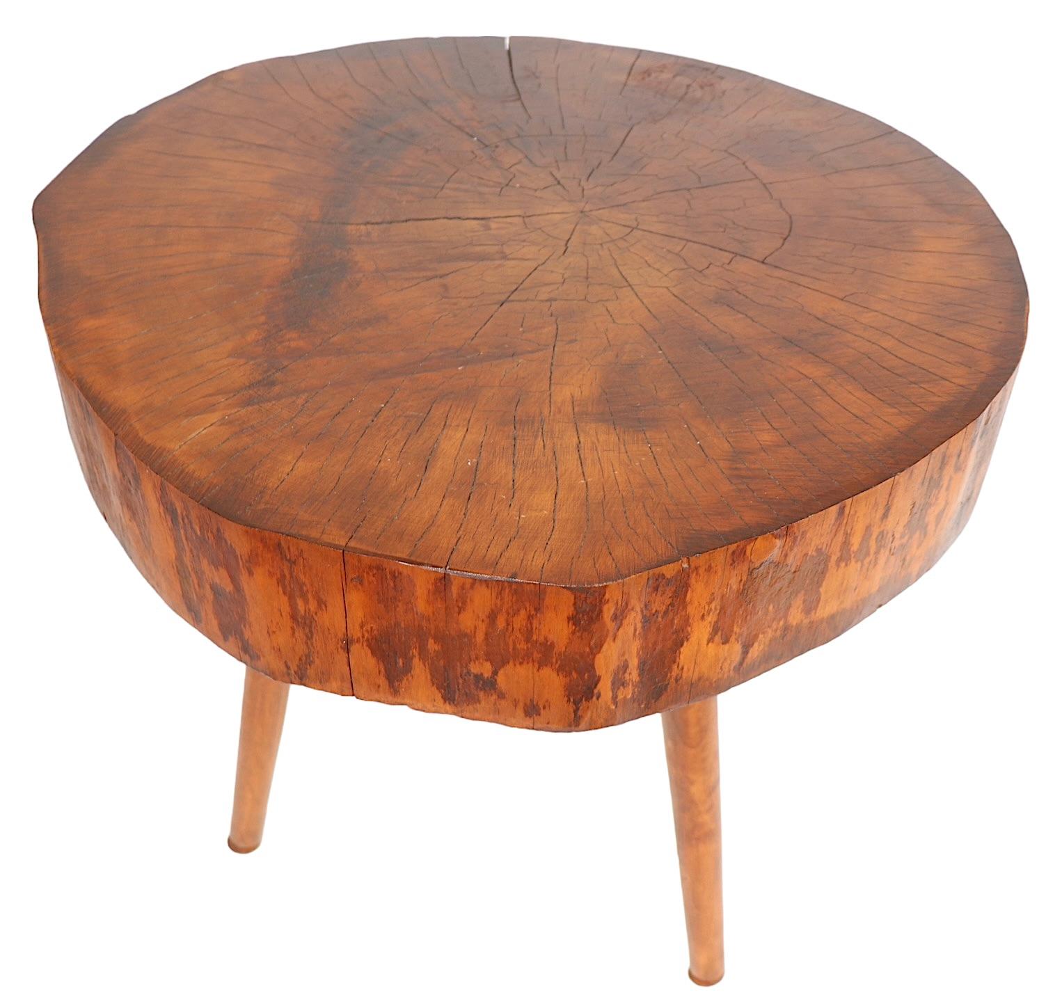 Rustic Adirondack style side, or end table having a thick ( 4 inch ) log top, on three screw in tapered pole legs. The table features a wonderful rich patinated surface, adding to the charm and beauty of this little gem. Made in the USA, circa
