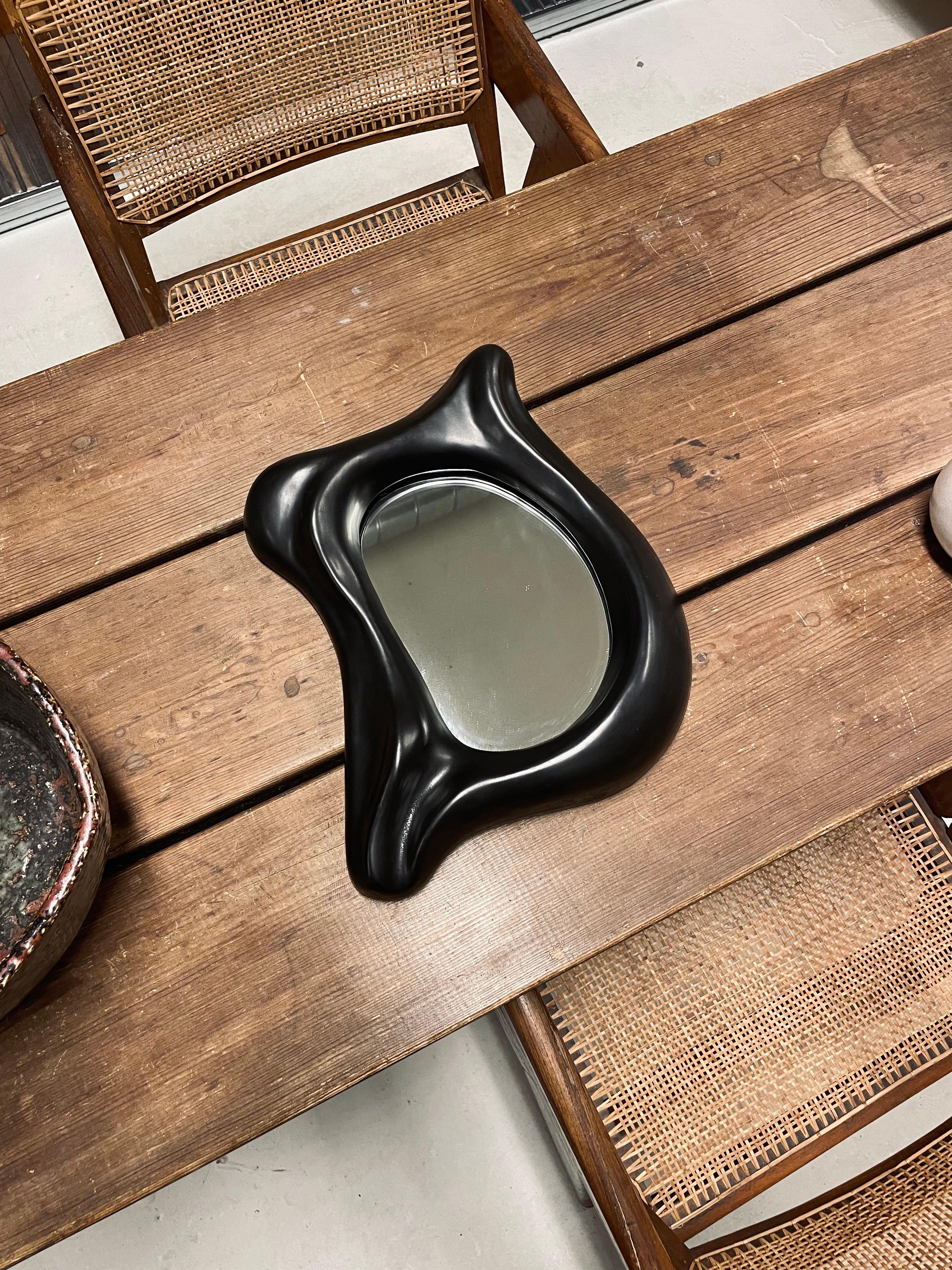 Very rare and beautiful mid century free form mirror in black glazed ceramic in style of Georges Jouve. In great vintage and original condition. 
Produced in France in the 1960s. 

Dimensions: H: 36 cm W: 32 cm D: 6 cm.