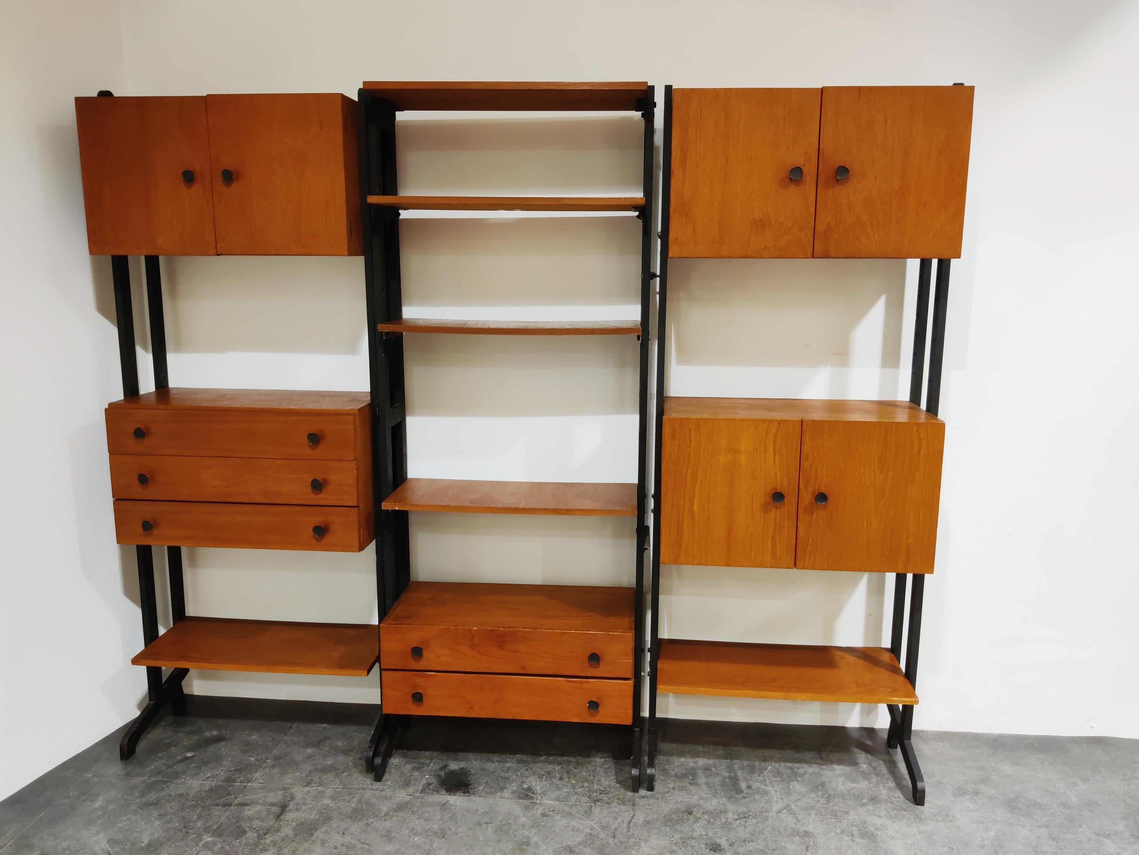 Vintage teak and black painted wooden wall unit manufactured by Simplalux.

Nicely shaped legs and doorhandles.

The wall unit provides enough storage space. Multiple cabinets and chests of drawers and shelves. 

Ideal to display diverse items
