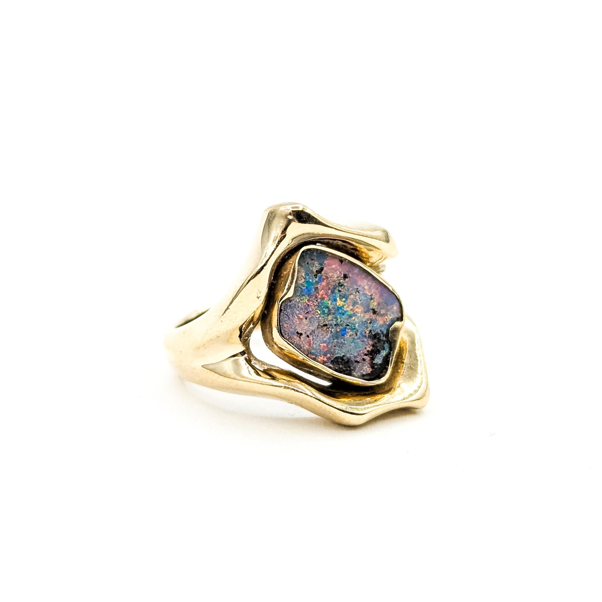 Anello Opale Australiano a forma libera di metà secolo in 14k

Questo anello è realizzato in oro giallo 14 carati e presenta un opale australiano a forma libera incastonato in un castone. L'opale mostra una miscela di toni blu, rosa e viola con aree