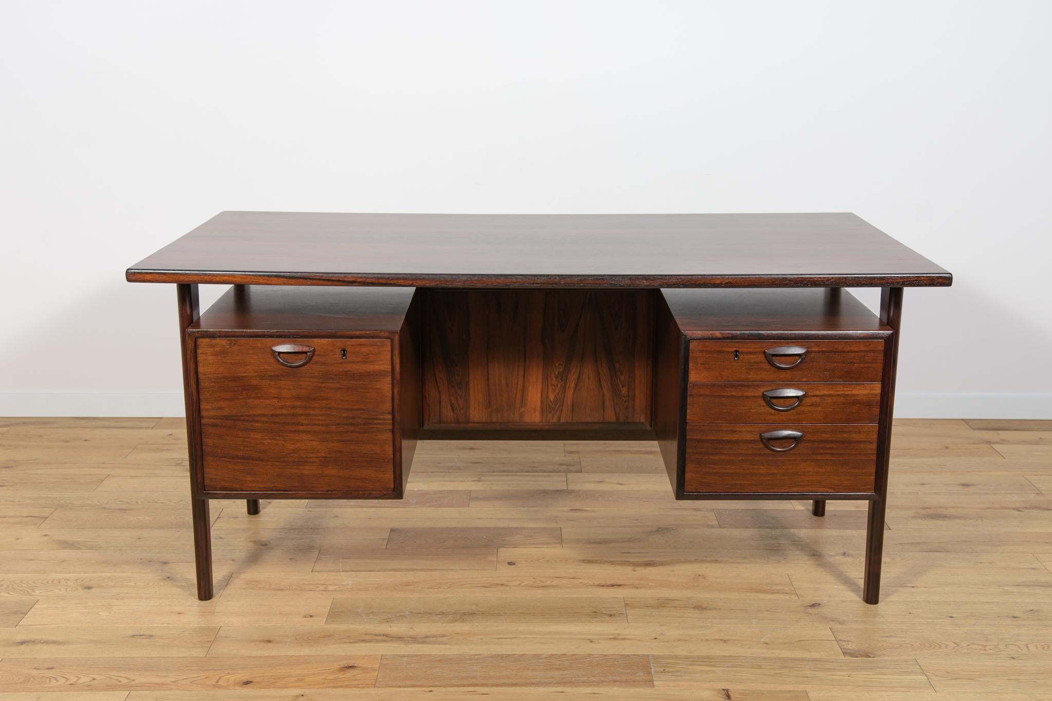 This desk designed Kai Kristiansen and manufactured by Feldballes Møbelfabrik in Denmark in the 1960s. It is a good example of high quality materials and manufacturing. This desk is made out of rosewood and is freestanding thanks to the finished