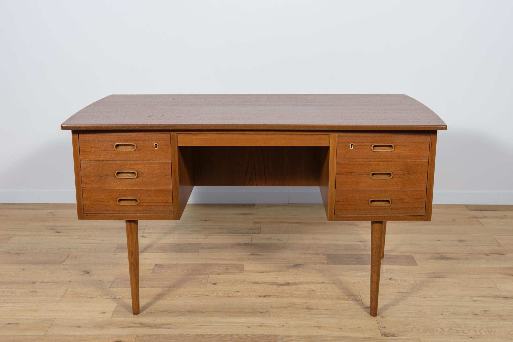 This desk made in Denmark in the 1960s. The desk is made of teak wood and is free-standing thanks to the finished back with an open storage space (bookcase). There are two modules at the front - three drawers each. The teak elements have been