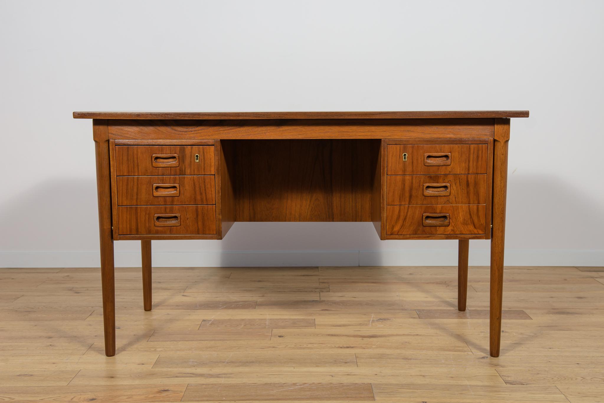 Questa scrivania è stata realizzata in Danimarca negli anni Sessanta. La scrivania è realizzata in legno di teak ed è indipendente grazie allo schienale rifinito con un vano portaoggetti aperto (libreria). Nella parte anteriore ci sono due moduli