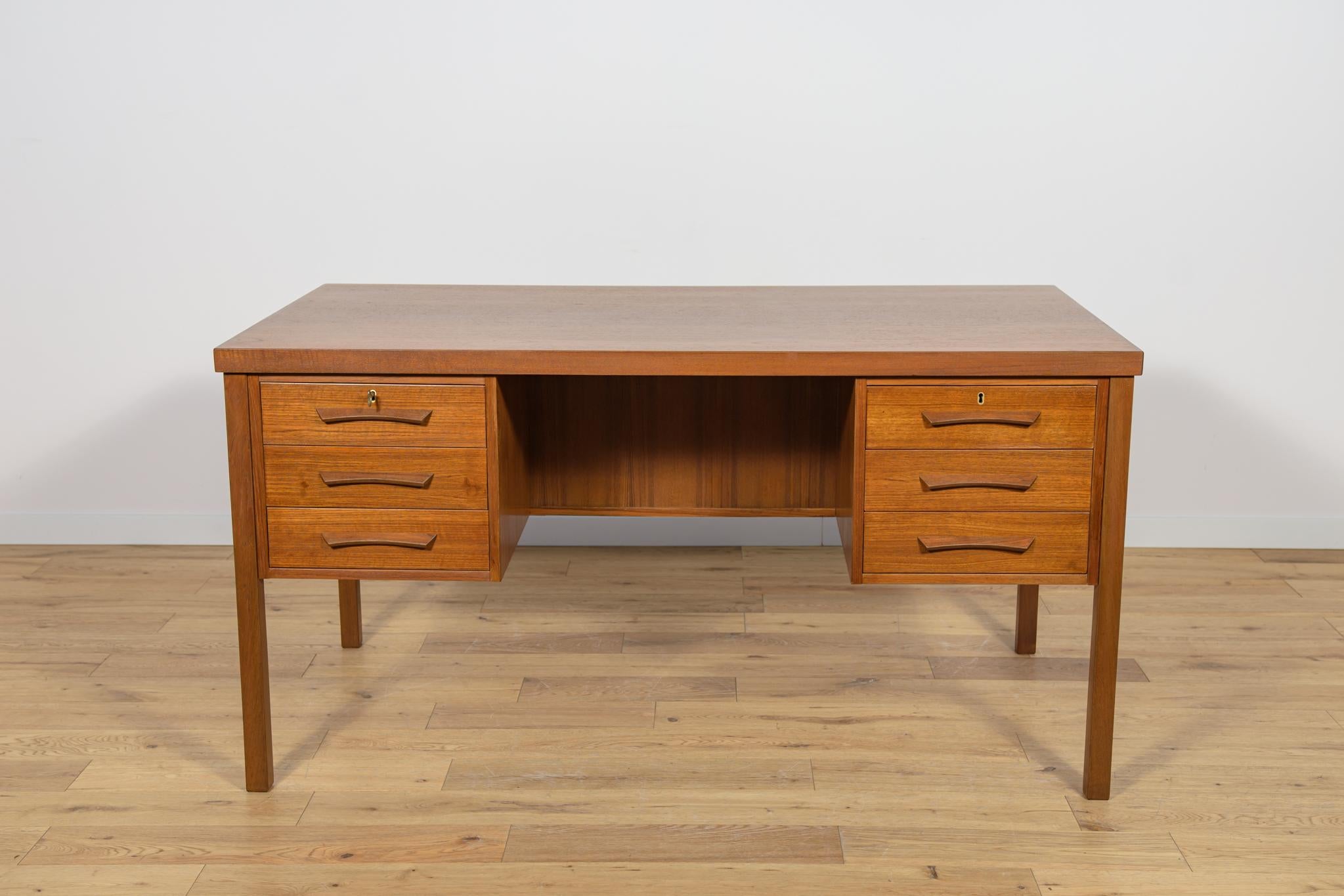 Questa scrivania è stata realizzata in Danimarca negli anni Sessanta. La scrivania è realizzata in legno di teak ed è indipendente grazie allo schienale rifinito con un vano portaoggetti aperto (libreria). Nella parte anteriore ci sono due moduli