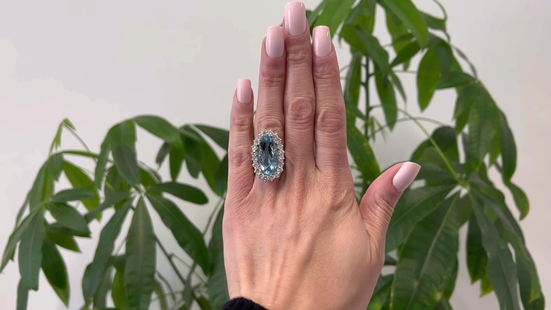 One Mid Century French 10.23 Carats Aquamarine Diamond Platinum Cluster Ring. Featuring one oval mixed cut aquamarine weighing 10.23 carats. Accented by 20 round brilliant cut diamonds with a total weight of approximately 2.00 carats, graded E-F