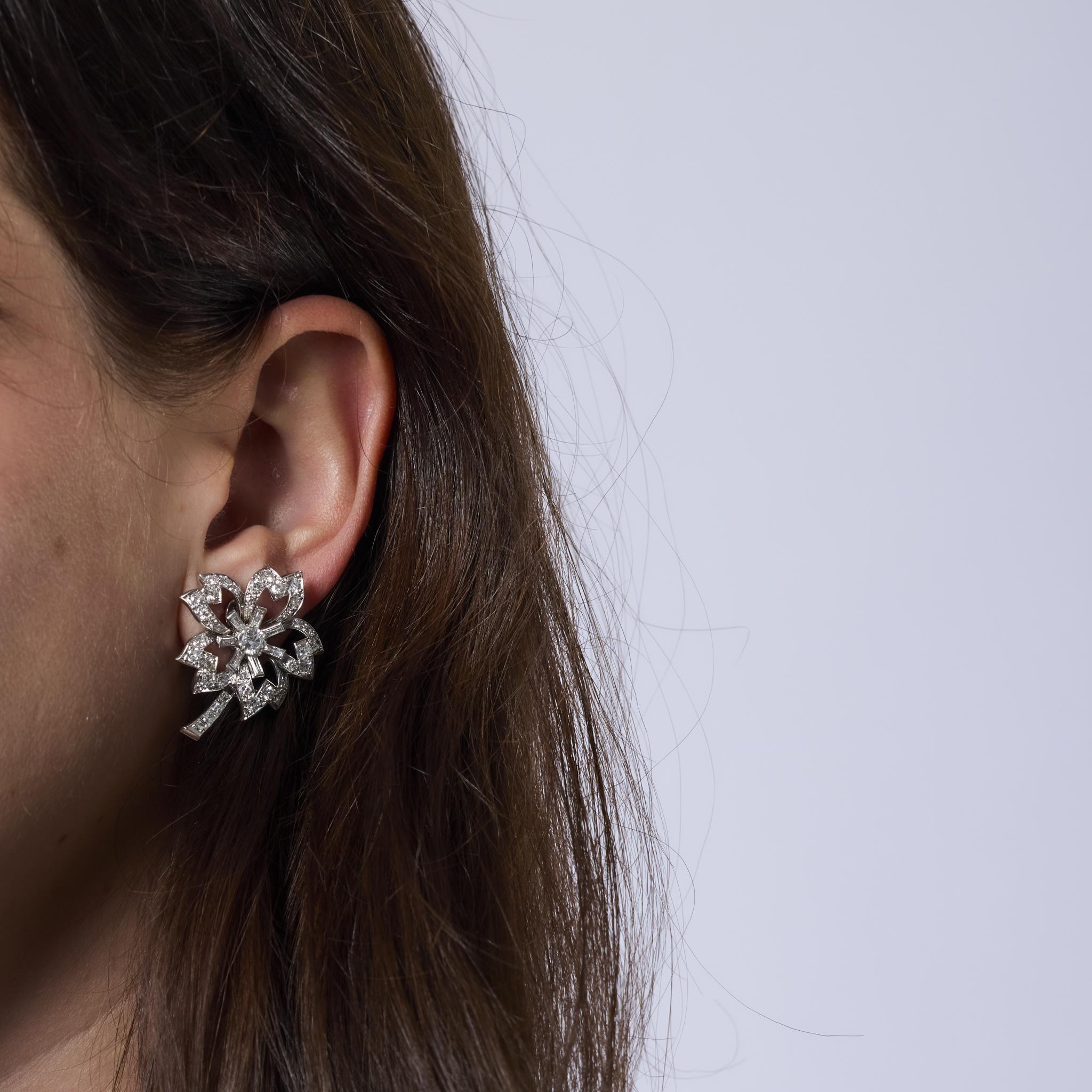 These glamorous Mid Century earrings shimmer with 90 round brilliant, old European, and baguette cut diamonds set in platinum. A dazzling 1960s design blending bold elegance and timeless French sophistication.